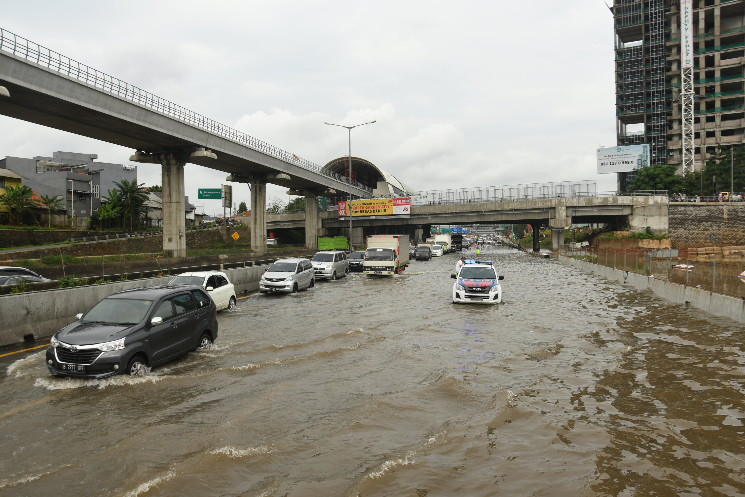 Kendaraan menerjang banjir yang menggenangi kawasan Tol Jatibening, Bekasi, Selasa (25/2).