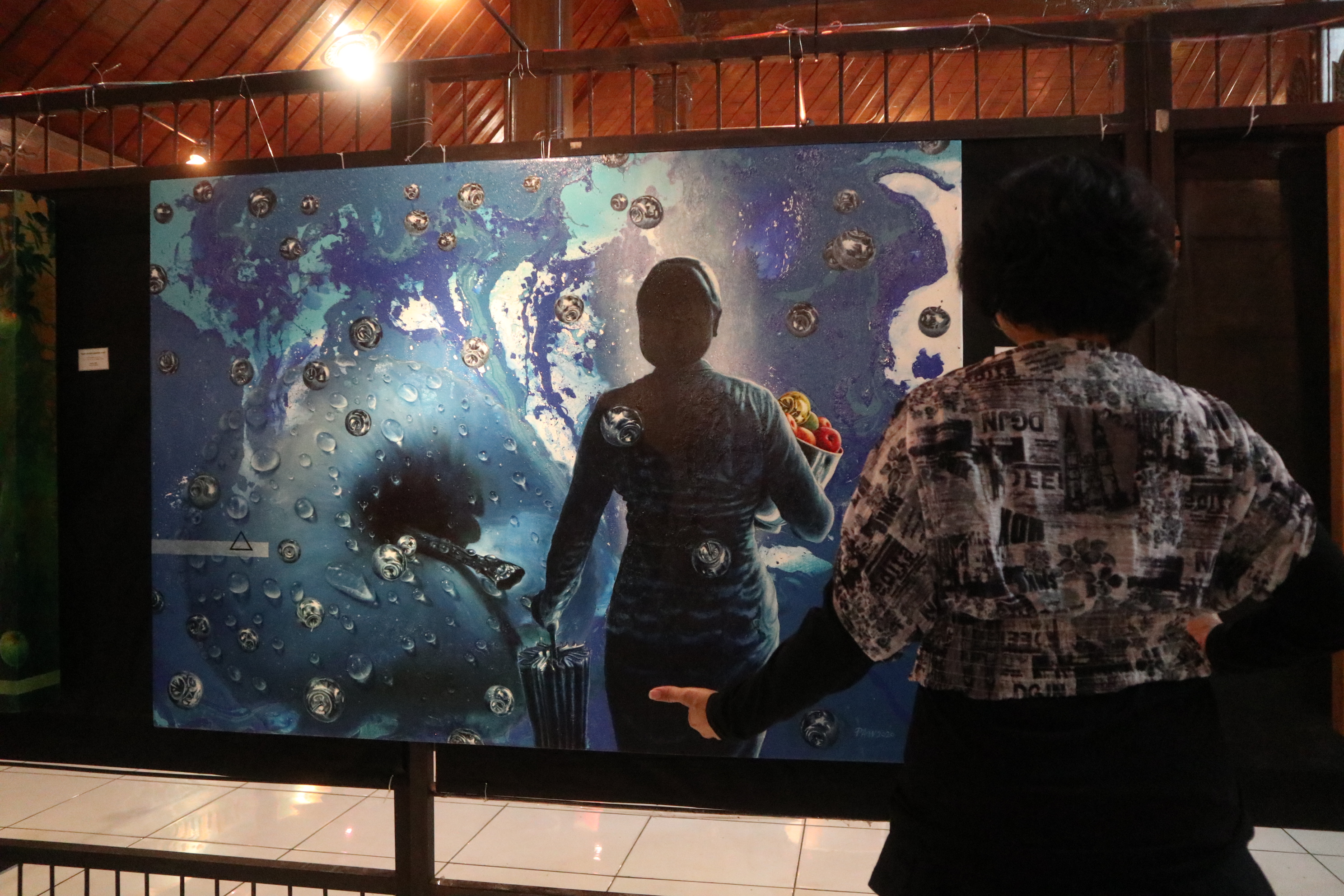 Pengunjung menikmati pameran seni rupa.