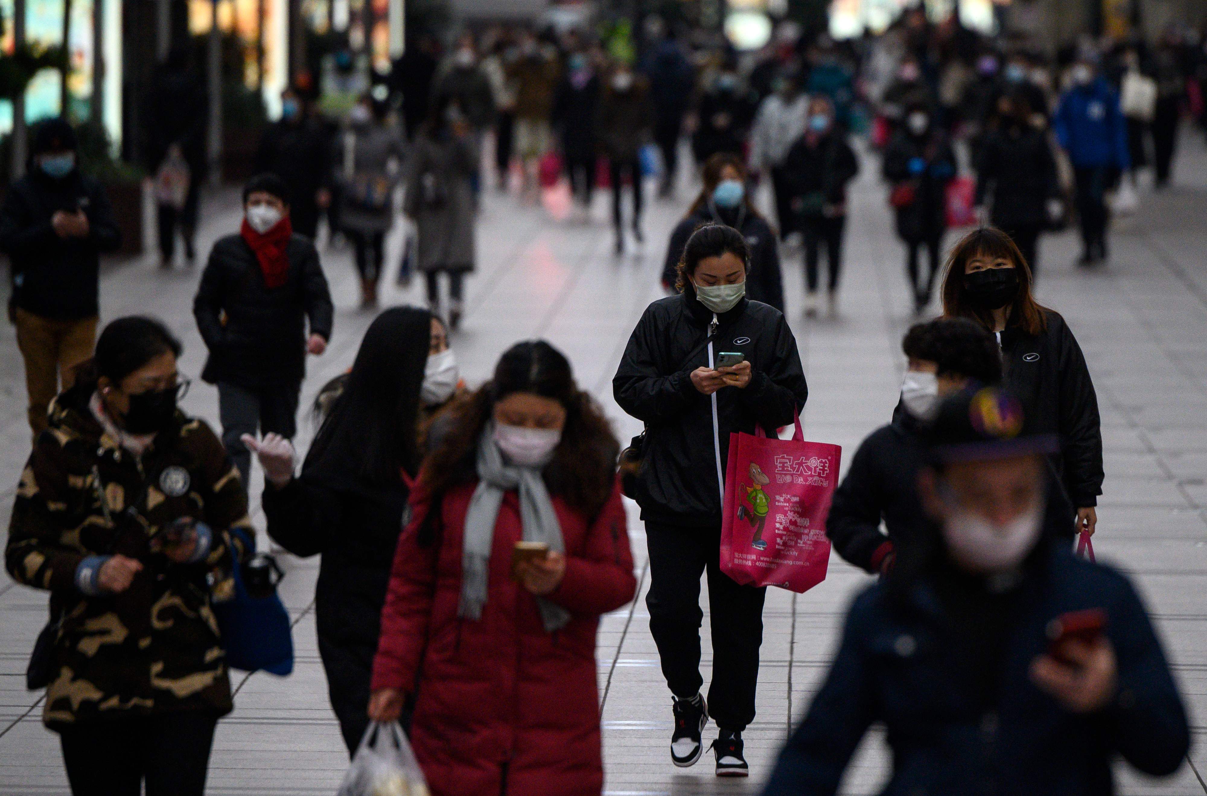 Warga mengenakan masker saat berjalan di pusat kota Shanghai, Tiongkok