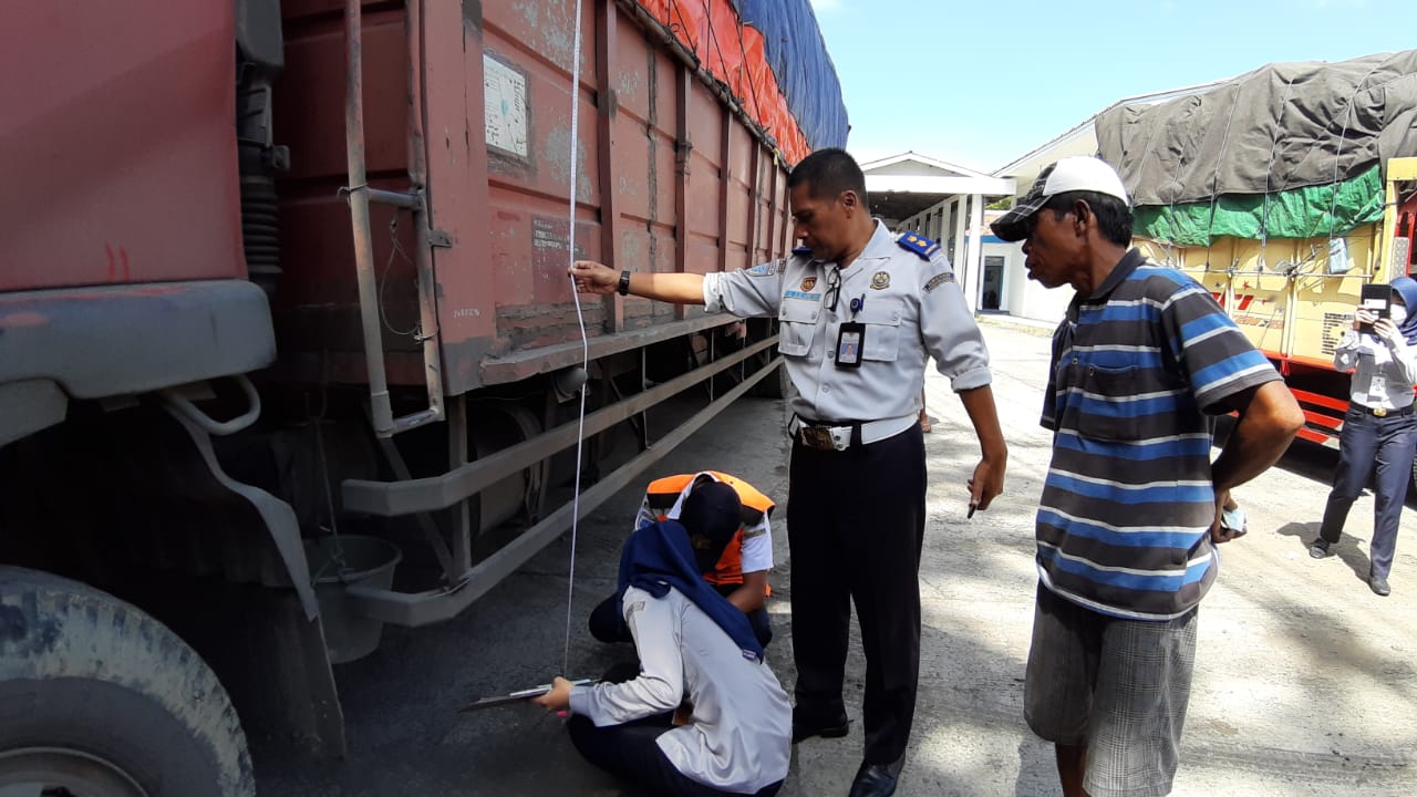 Petugas UUPKB Tanjung Brebes sedang mengukur dimensi kendaraan.