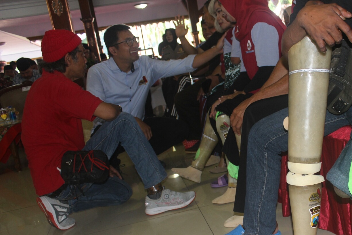 Ketua Kick Andy Foundation Ali Sadikin dan produsen kaki palsu Sugeng Siswoyudono memasang kaki palsu di Blitar, Jawa Timur, Sabtu (15/2).