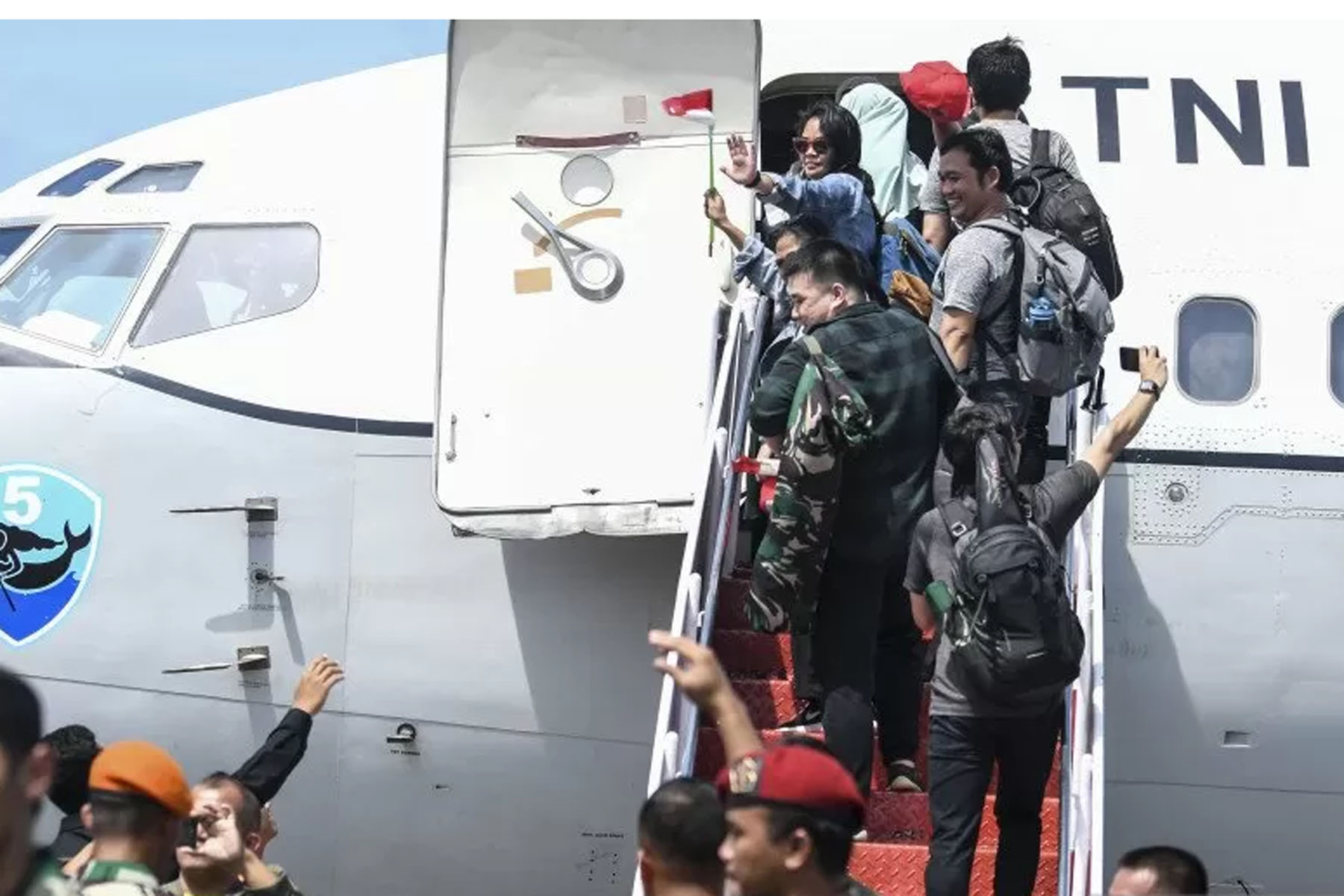 WNI yang telah menjalani observasi menaiki tangga pesawat di Pangkalan Udara TNI AU Raden Sadjad, Natuna, Kepulauan Riau, Sabtu (15/2). 