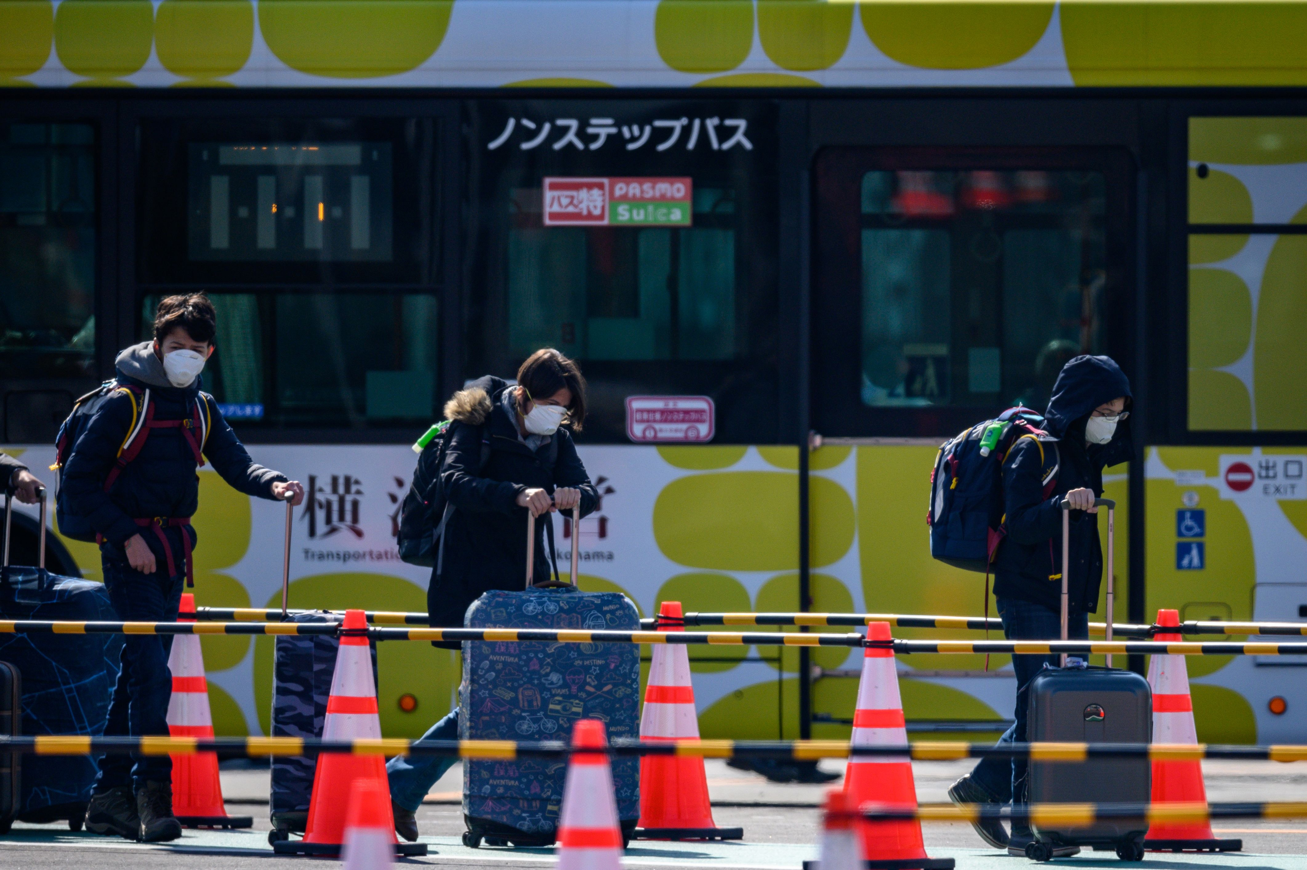 Penumpang Kapal Diamond Princess berjalan menuju Bus dengan menggunakan Masker.