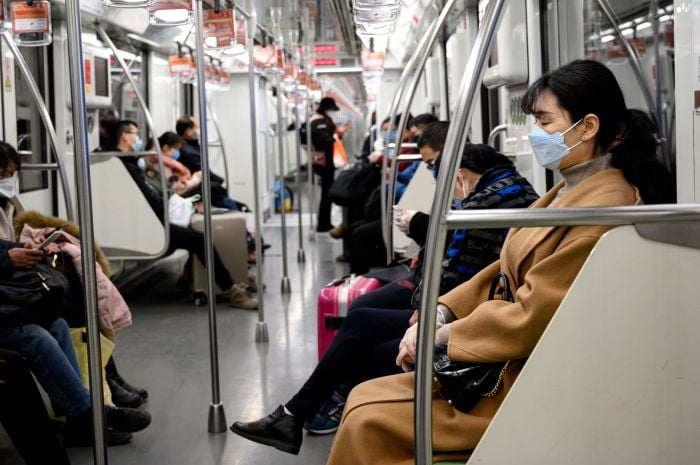 Warga mengenakan masker saat menumpang kereta di Shanghai, Tiongkok