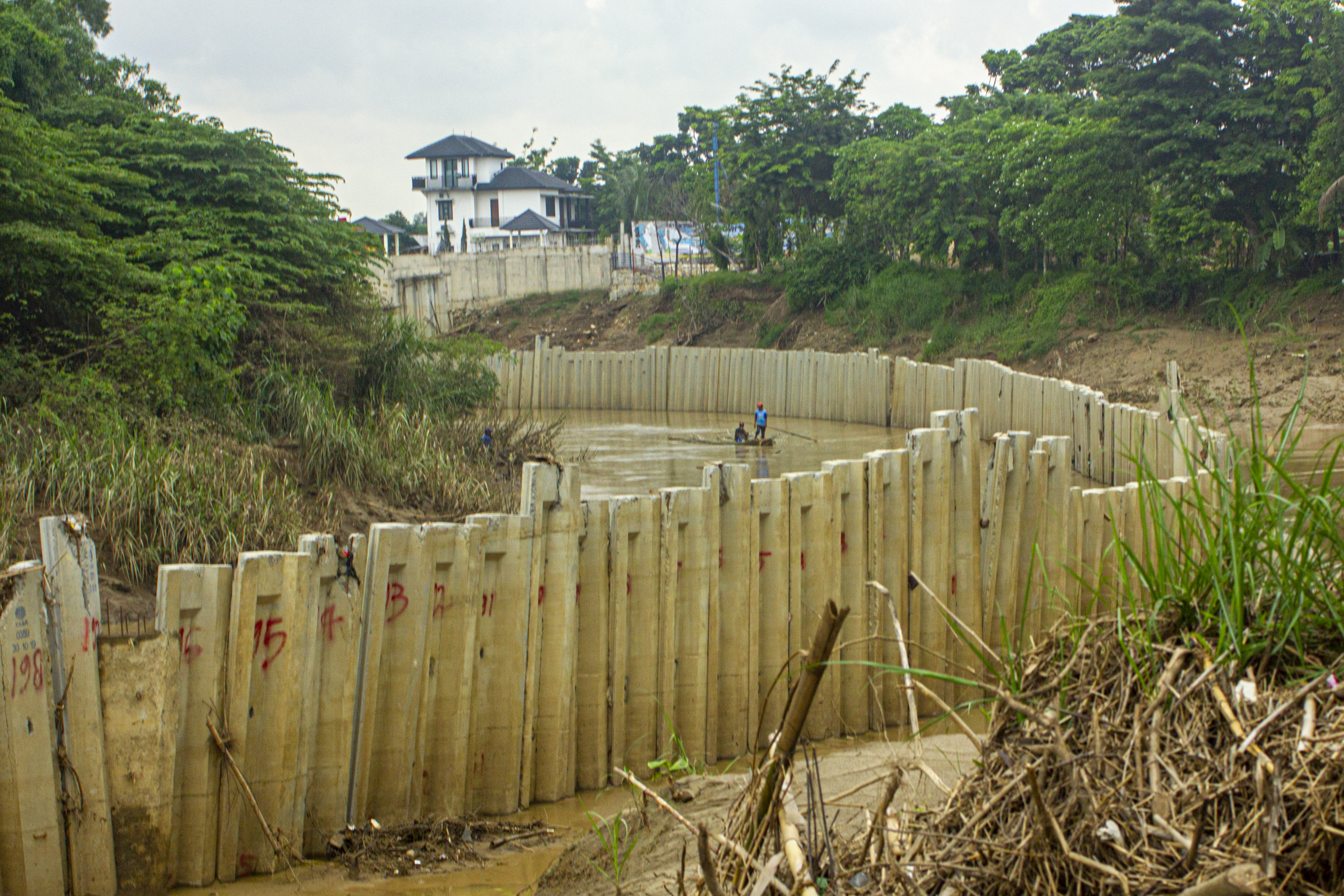  Warga menggunakan perahu rakit saat melintasi sungai Cibeet yang terpasang dinding turap (sheet pile) di Karawang, Jawa Barat, Jumat (31/1)