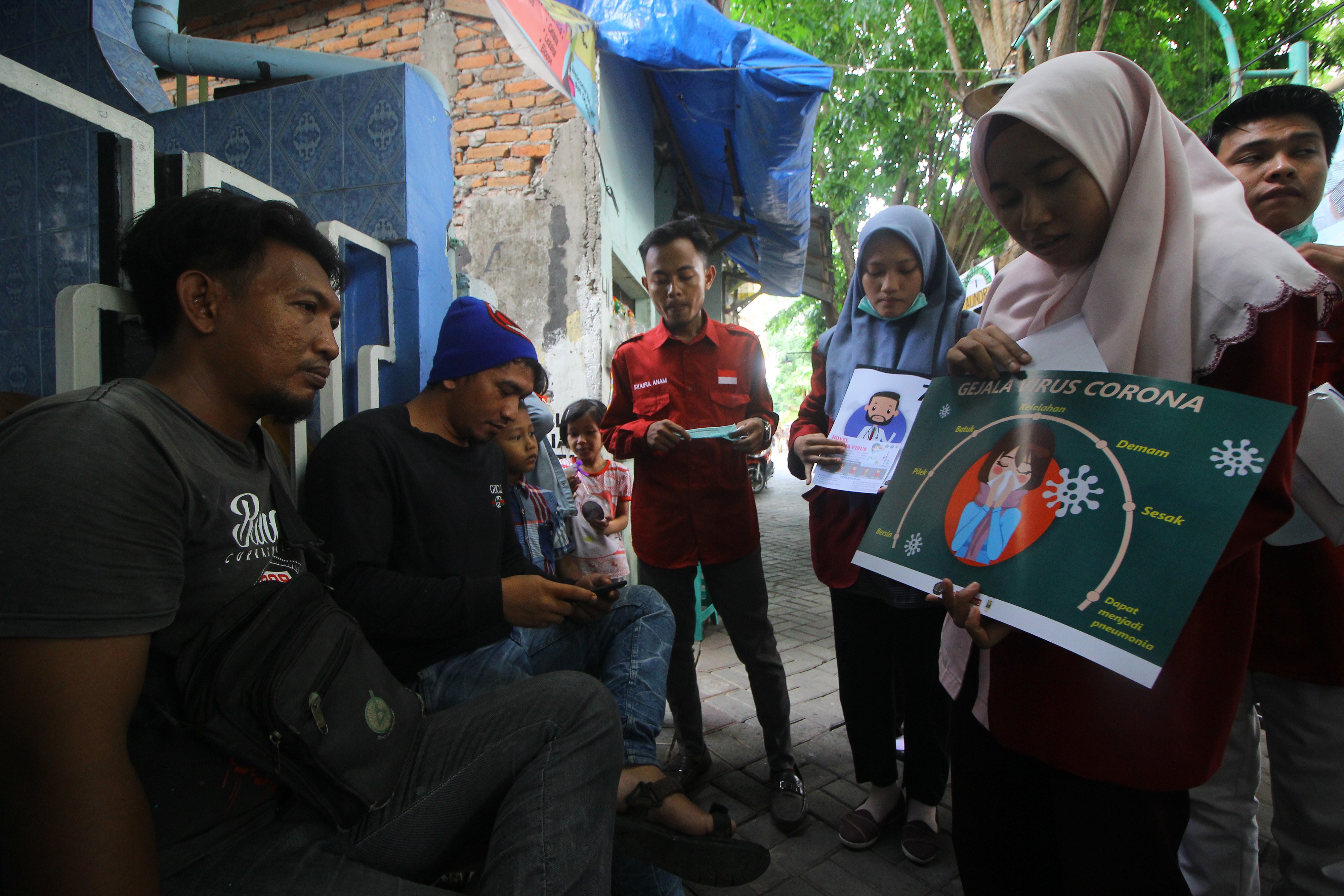 Mahasiswa Fakultas Ilmu Kesehatan (FIK) Universitas Muhammadiyah Surabaya memberi penjelasan kepada warga akan bahaya virus korona.