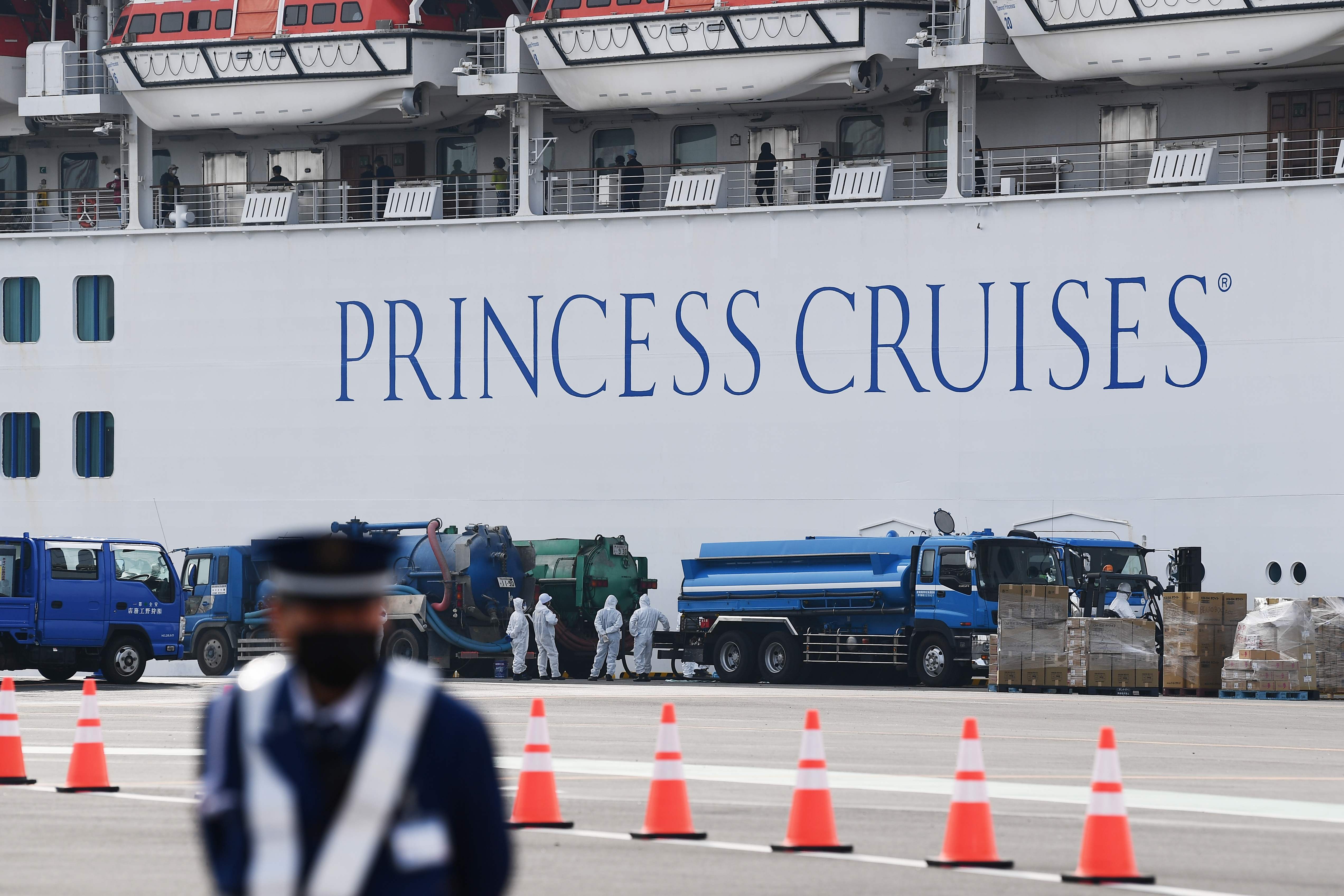 Seorang penjaga terlihat di depan kapal pesiar Diamond Princess yang bersandar di Pelabuhan Yokohama, Jepang.