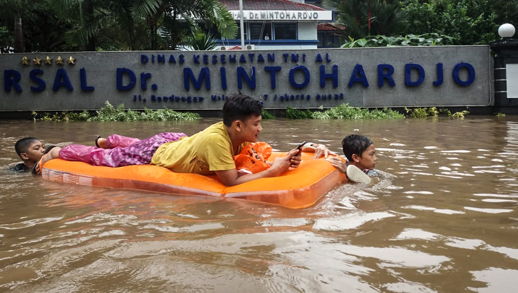 Warga melewati banjir di depan RSAL Dr. Mintohardjo kawasan Benhil, Jakarta, Selasa (25/2/2020). 
