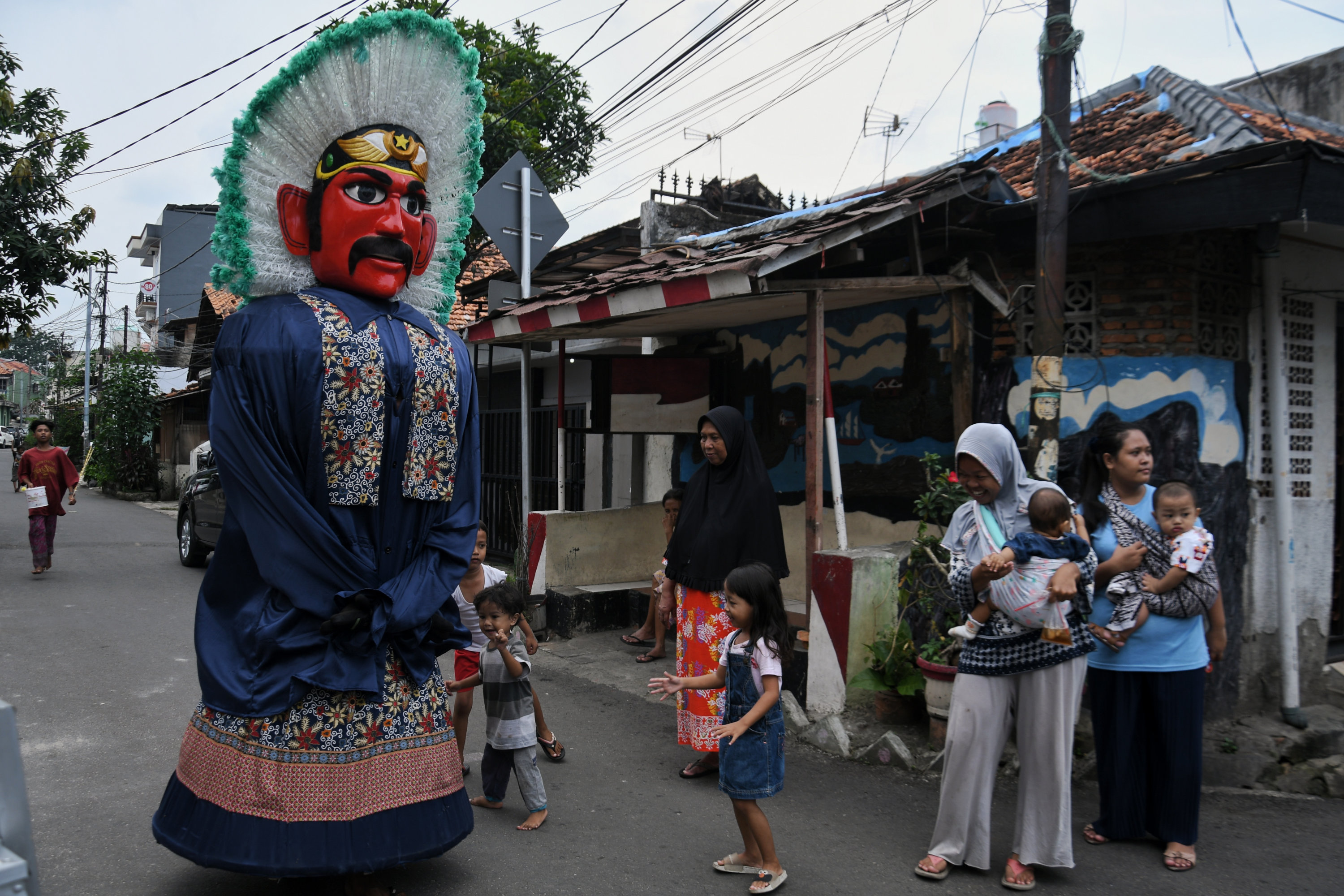 Pengamen ondel-ondel beraksi di kawasan Matraman, Jakarta.