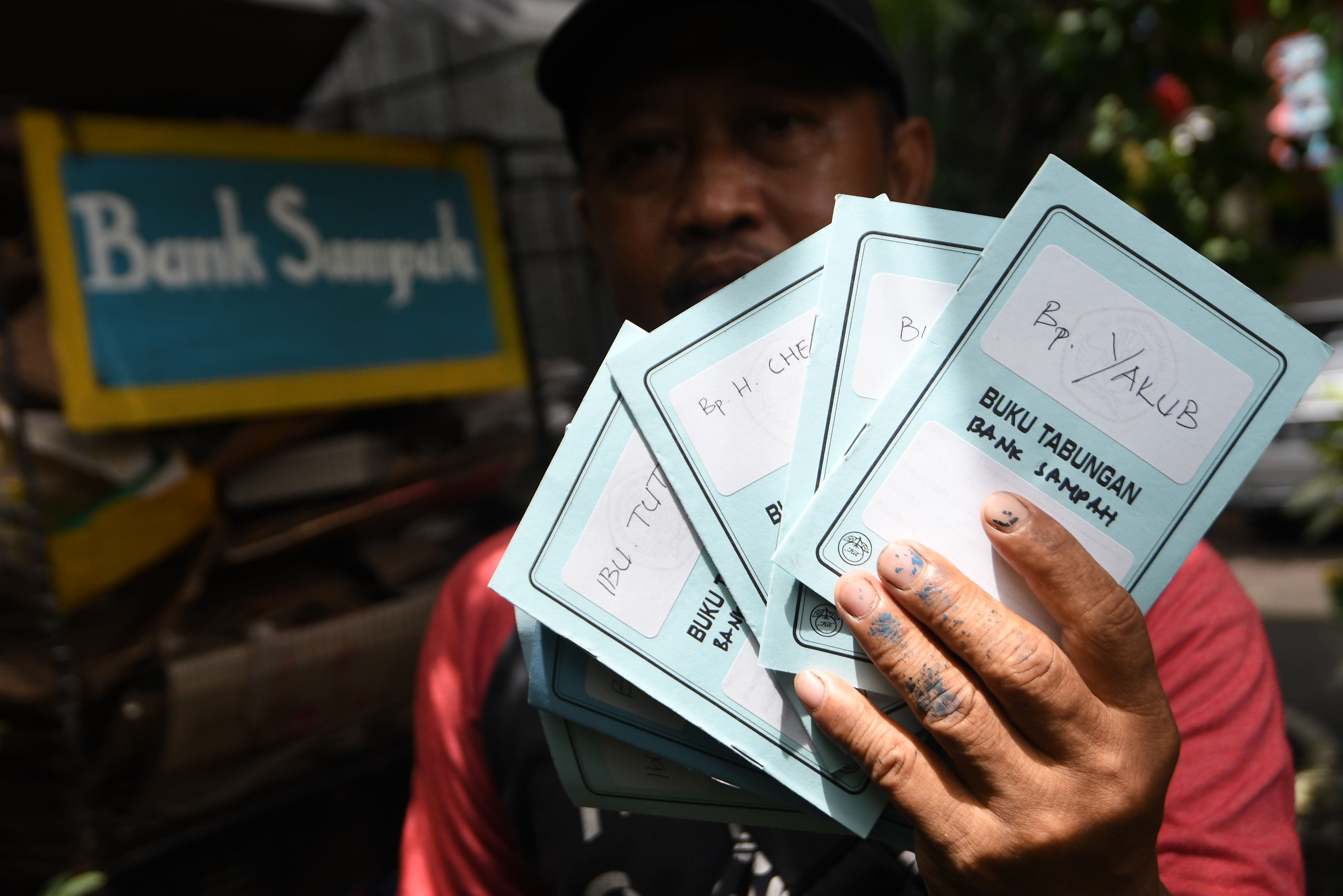 Relawan menunjukkan buku tabungan Bank Sampah Kampung Hijau yang menjadi program Sampah Tanggung Jawab Bersama (Samtama) di Jakarta.