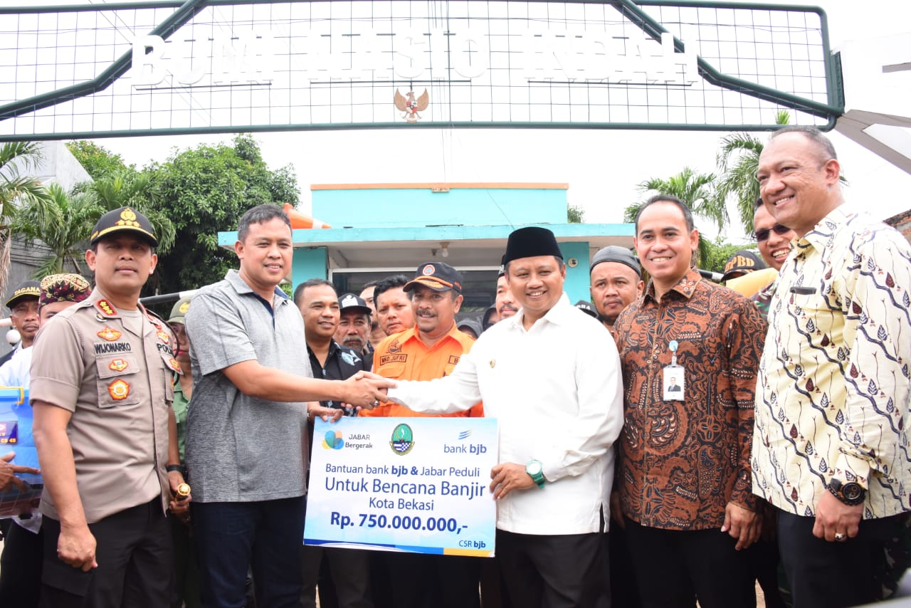 Wakil Gubernur Jawa Barat  Uu Ruzhanul Ulum ( ketiga dari kanan) memberi bantuan secara simbolis seusai meninjau banjir di Bekasi. 