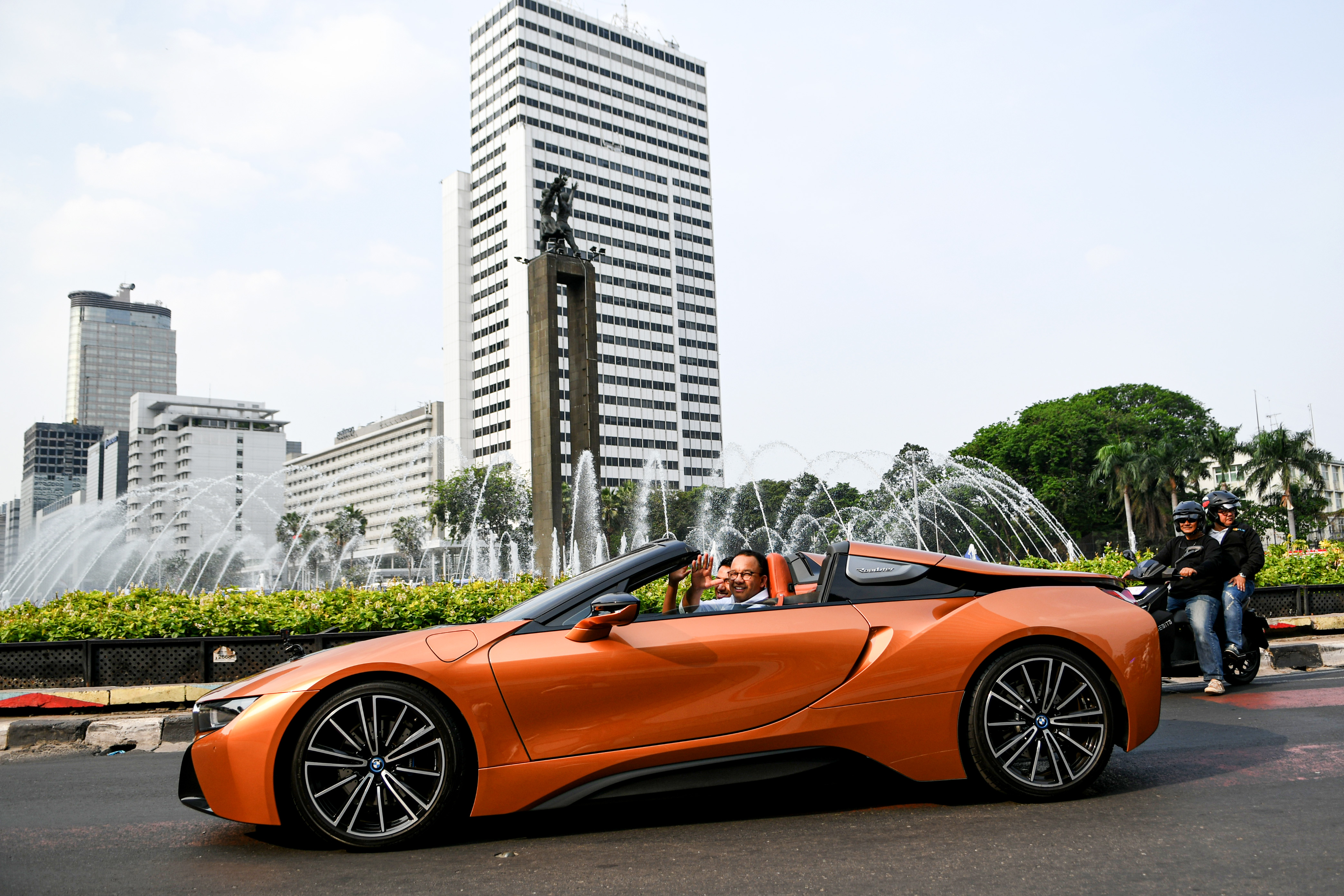 Gubernur DKI Jakarta Anies Baswedan di dalam mobil listrik ketika mengikuti konvoi di Bundaran Hotel Indonesia, Jakarta.