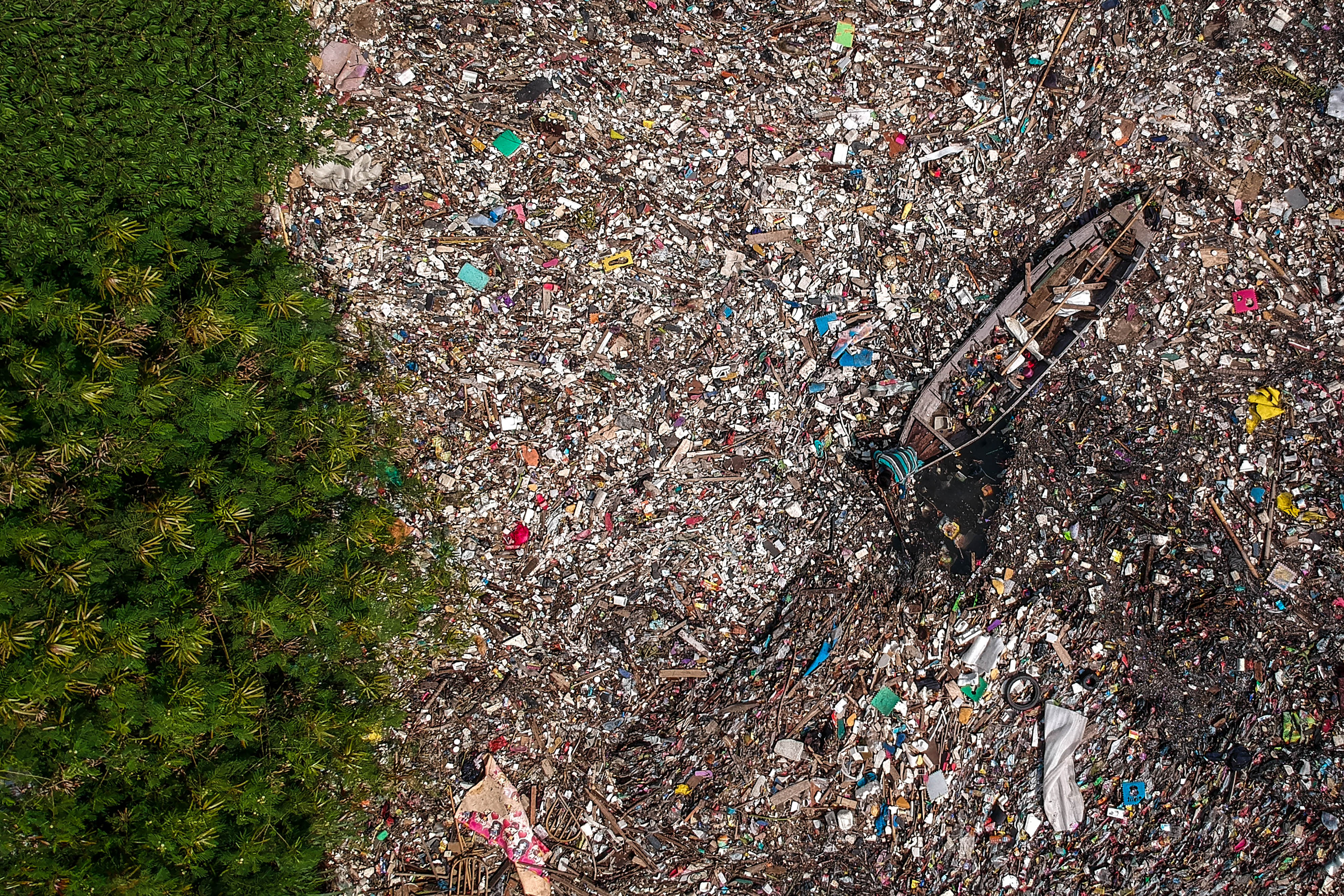 Seorang warga mengumpulkan sampah plastik di Sungai Citepus yang bermuara ke Sungai Citarum di Bojong Citepus, Dayeuhkolot.
