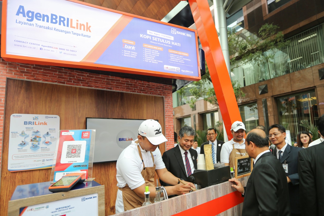 Dirut BRI Sunarso memperhatikan cara kerja agen BRILink. 