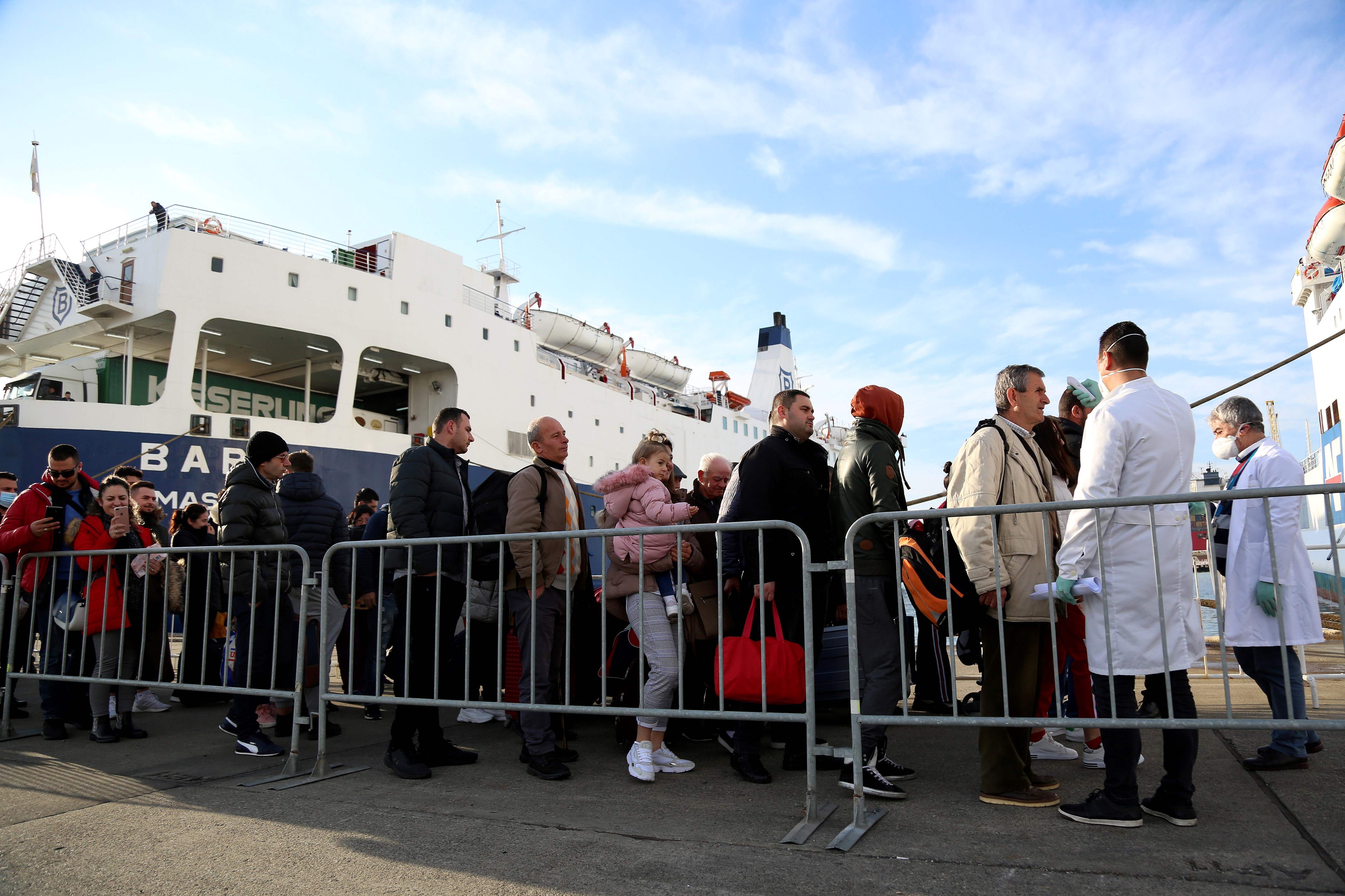 Petugas medis di Albania melakukan pengecekan terhadap penumpang yang berasal dari Italia, untuk mengantisipasi penyebaran virus korona.