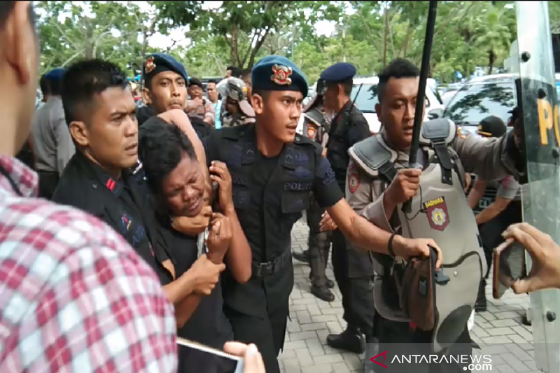 Polisi saat mengamankan dua orang pemuda yang diduga pembuat onar di area pelaksanaan Kongres ke V PAN di Sultra. (ANTARA)