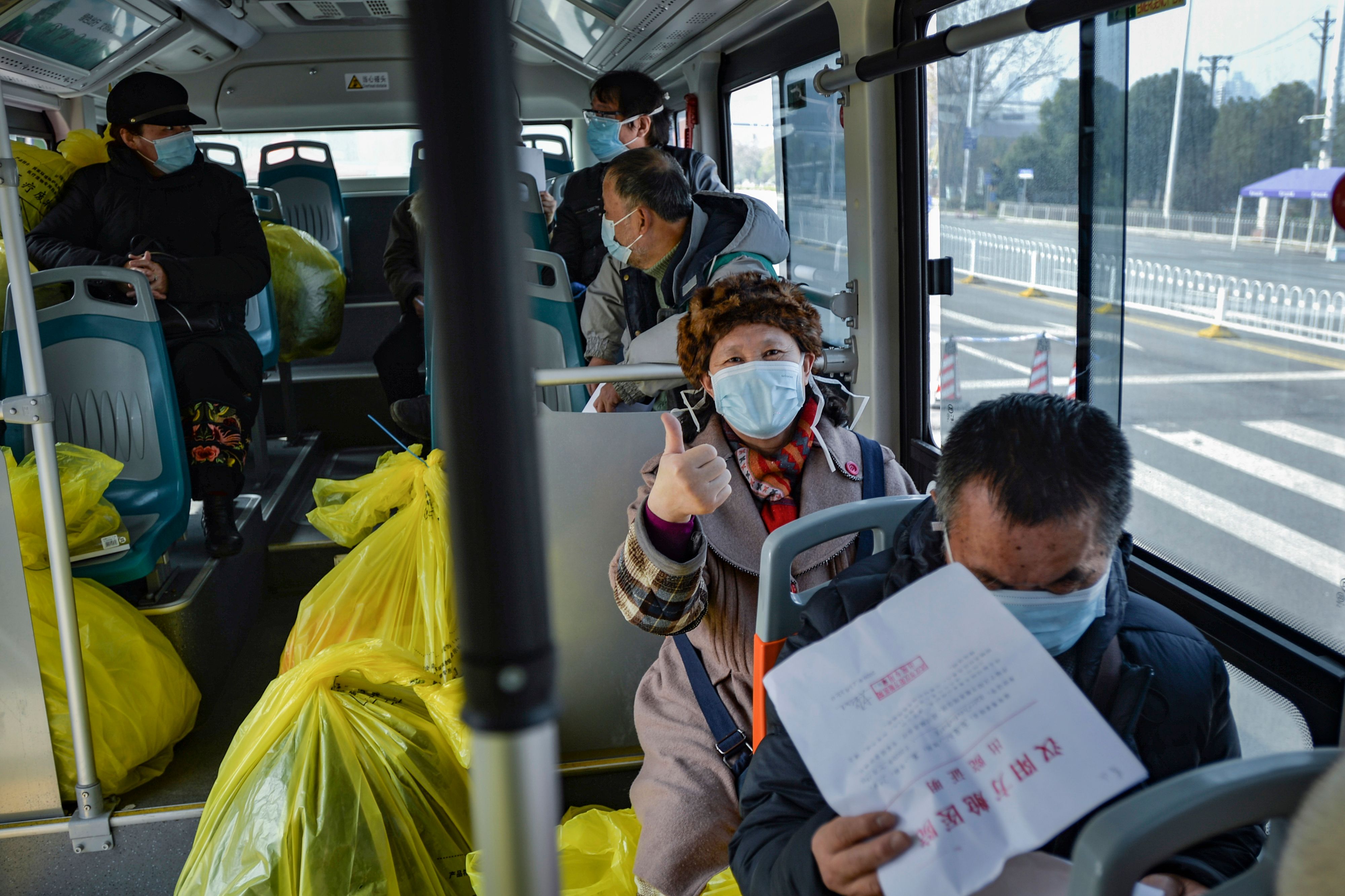 Warga yang dinyatakan telah sembuh dari virus korona meninggalkan rumah sakit menggunakan bus di Wuhan, Tiongkok.