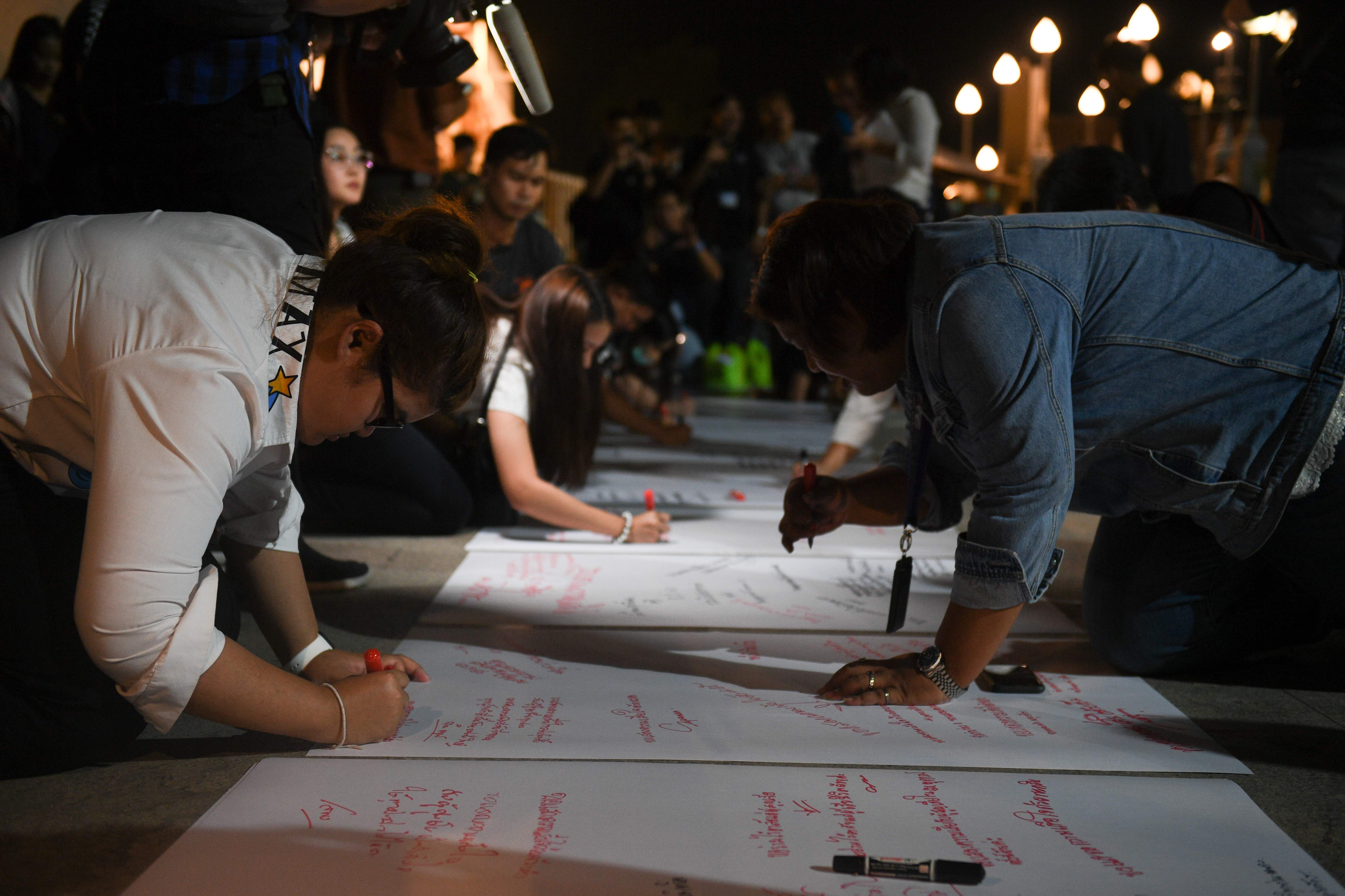 Warga Thailand menuliskan pesan duka cita untuk para korban penembakan di Nakhon Ratchasima, Thailand.