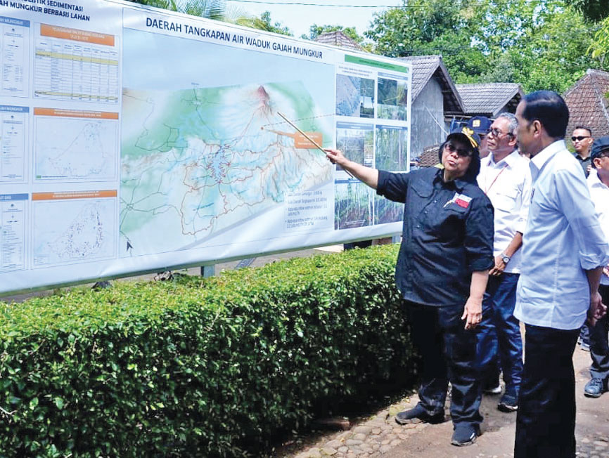 Presiden Joko Widodo mendapat paparan dari Menteri Lingkungan Hidup dan Kehutanan Siti Nurbaya saat bersama ratusan warga menanam akar wangi