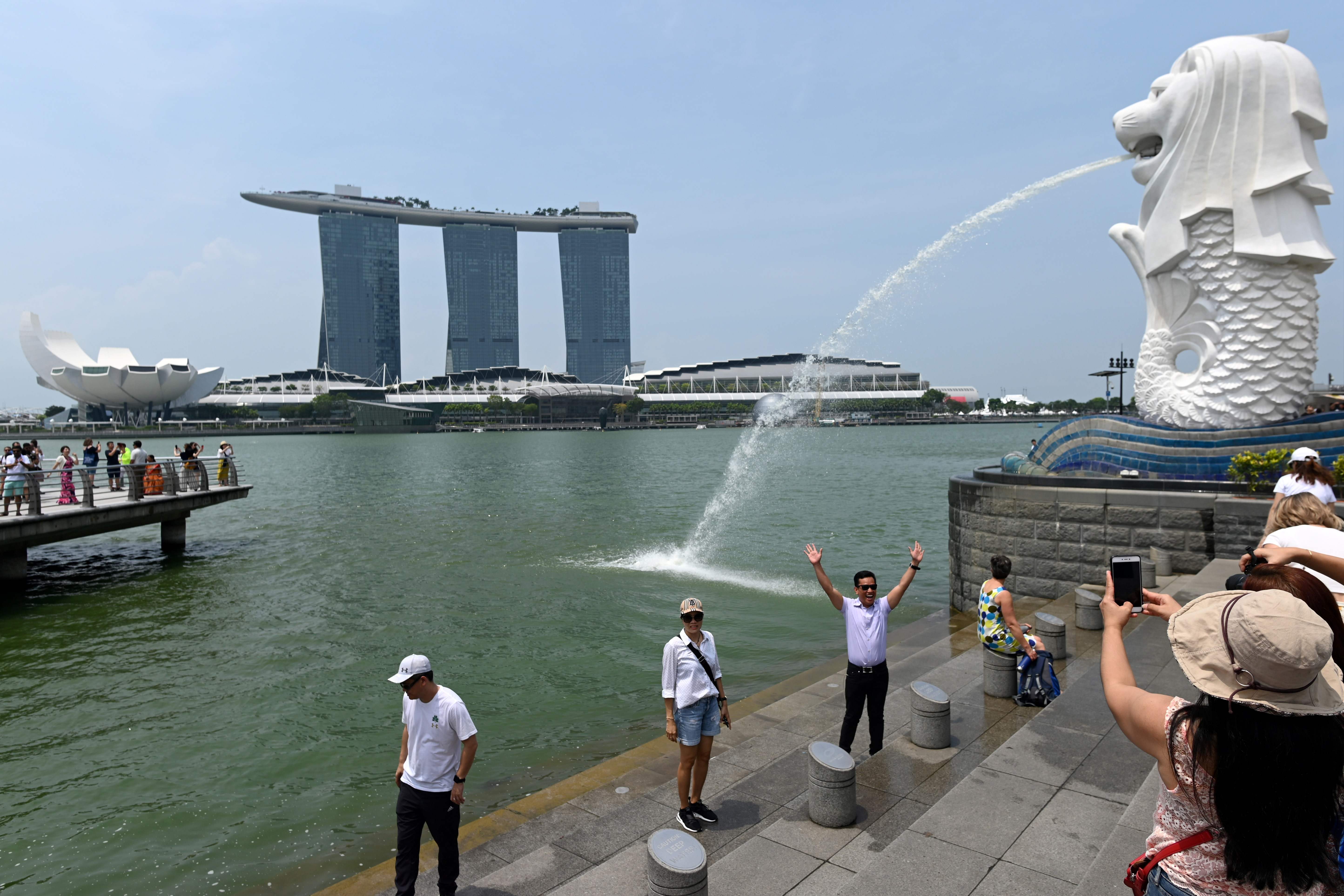 Sejumlah wisatawan mengambil gambar di dekat patung Merlion, lambang Singapura.