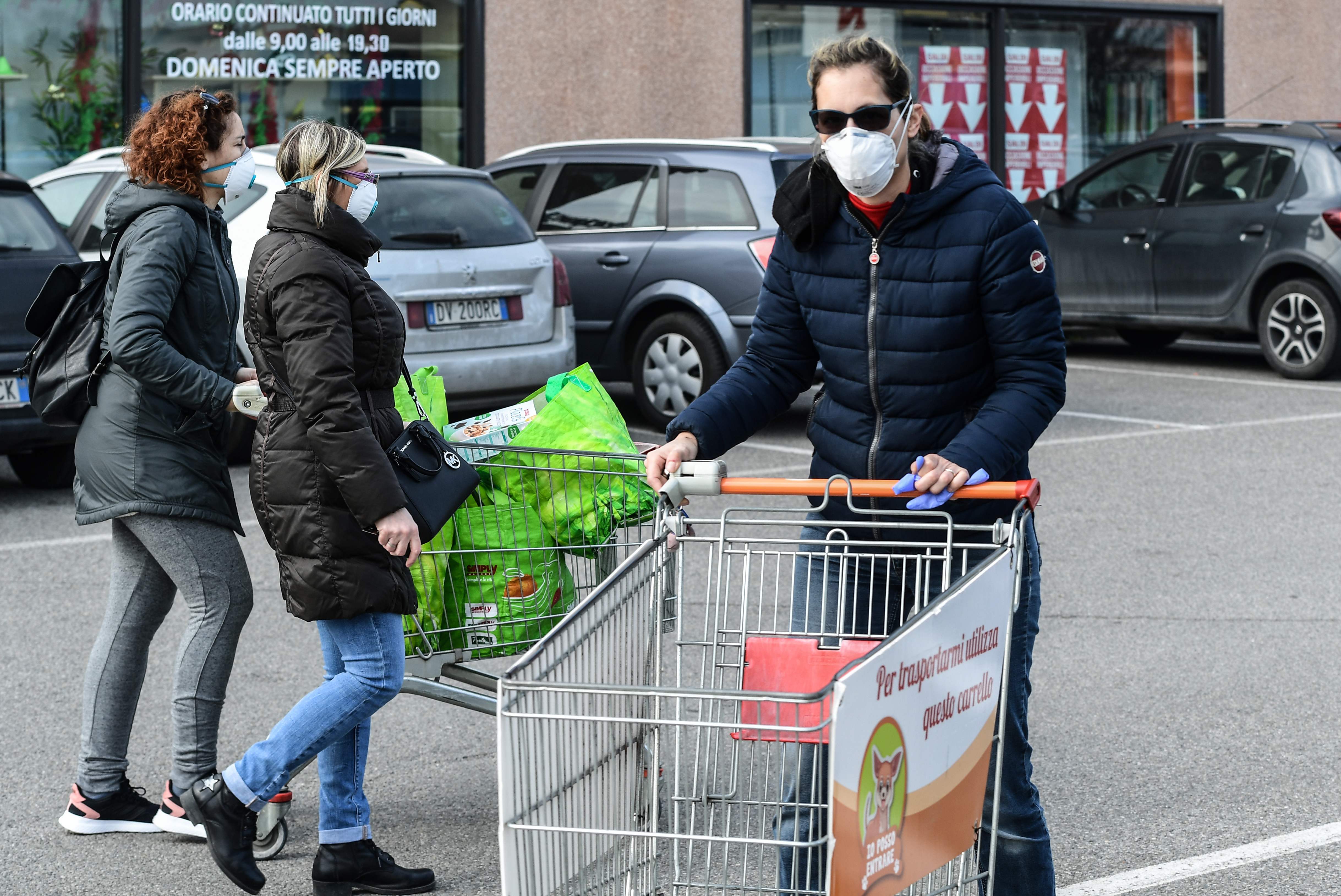 Sejumlah warga di Casalpusterlengo, Italia mengenakan masker saat beraktivitas di luar ruangan, untuk mencegah penularan virus korona. 