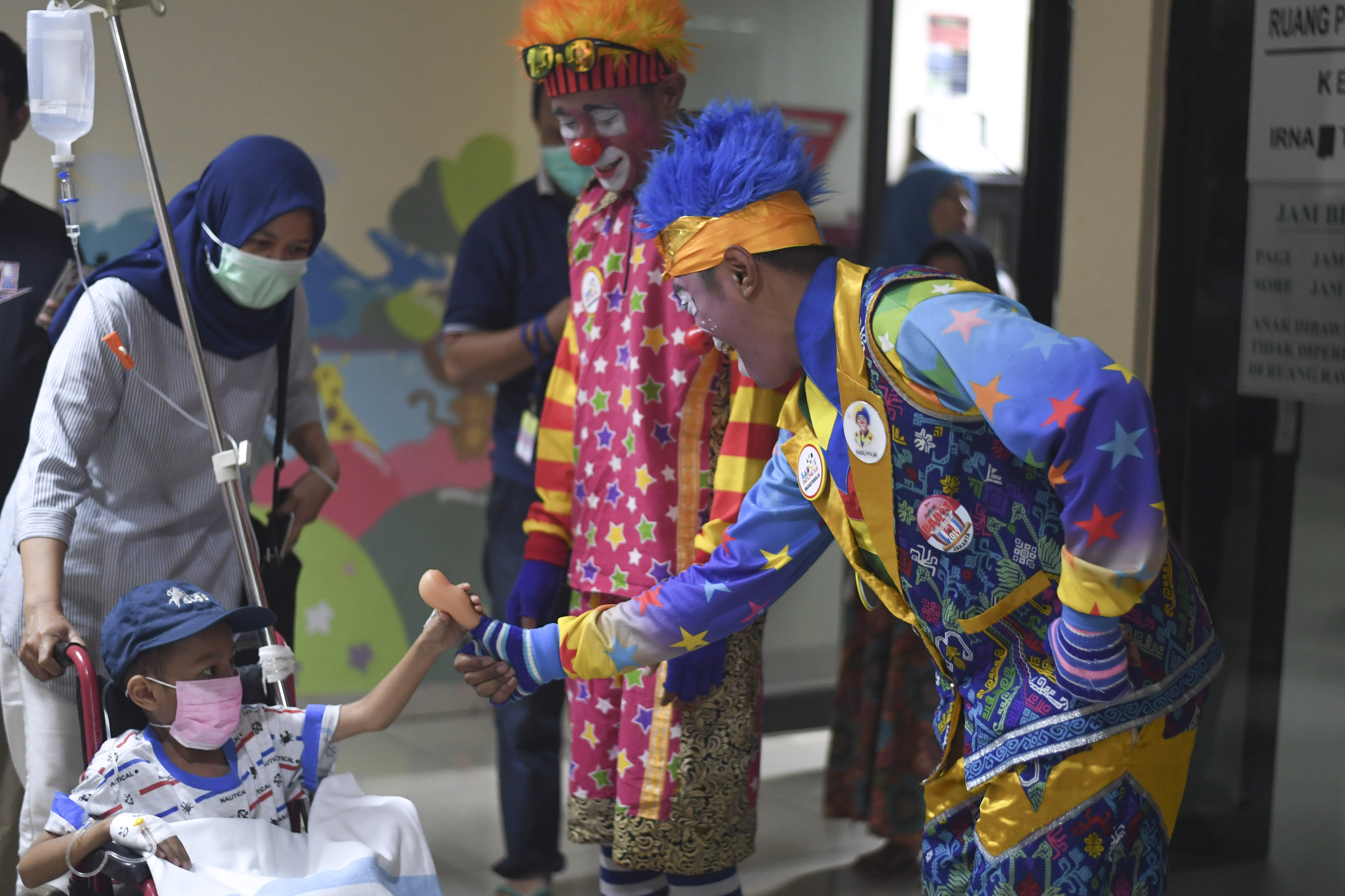 PERINGATAN HARI KANKER INTERNASIONAL: Dua badut yang tergabung dalam Aku Badut Indonesia (ABI) menghibur anak yang dirawat 