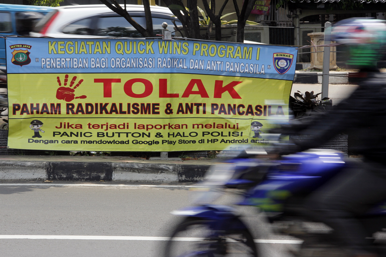  Pengendara motor melintas di dekat spanduk bertuliskan Tolak Paham Radikalisme & Anti Pancasila di Jalan Margonda, Depok