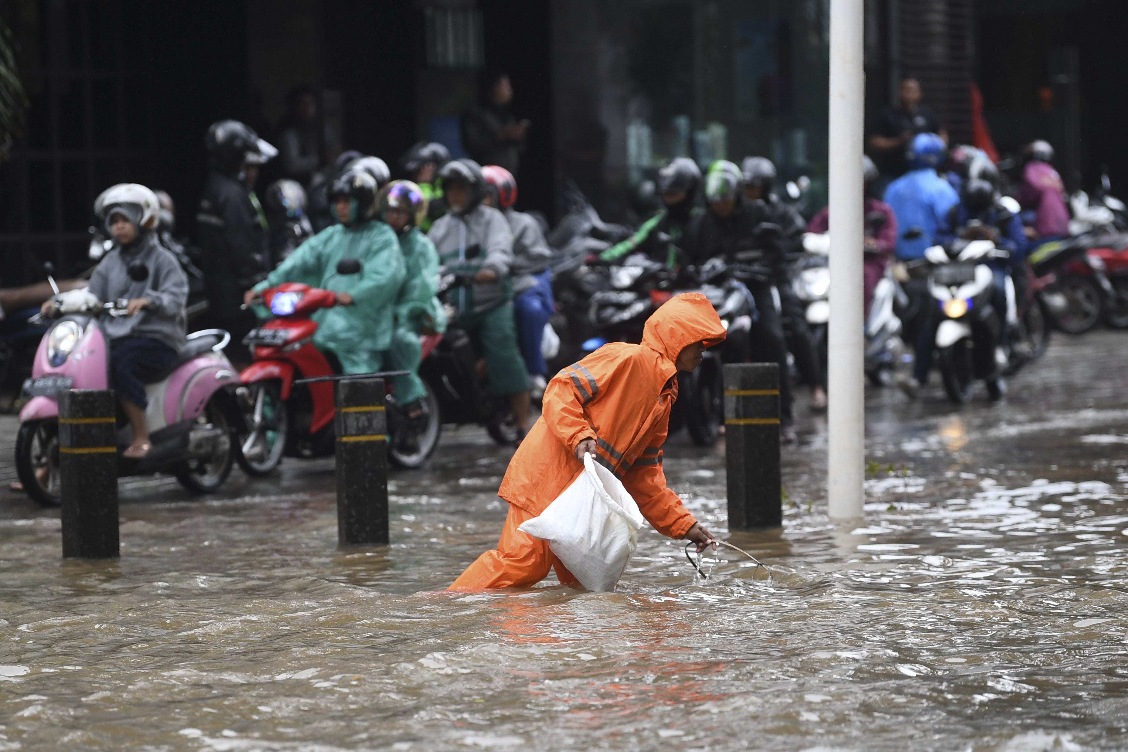 Petugas PPSU membersihkan sampah saat banjir di kawasan Kemang Raya, Jakarta.