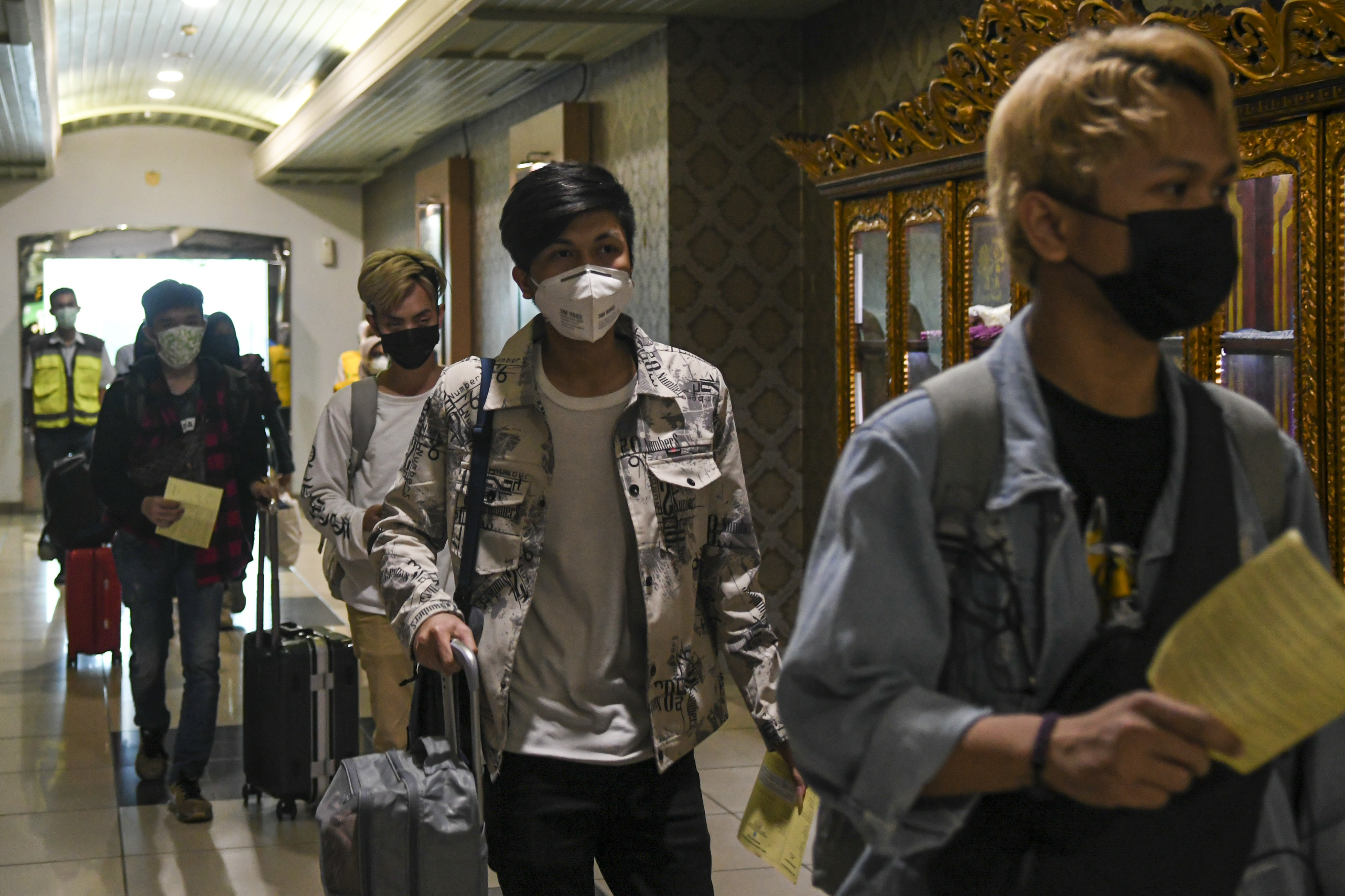 Para mahasiswa asal Sumatra Selatan yang baru pulang dari Tiongkok memasuki Bandara  Sultan Mahmud Badaruddin II Palembang.