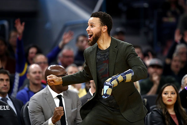 Stephen Curry yang terluka dari Warriors bereaksi di bangku cadangan