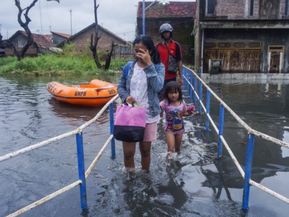 Warga melintasi banjir di Tirto, Pekalongan, Jawa Tengah, Kamis (20/2/2020).