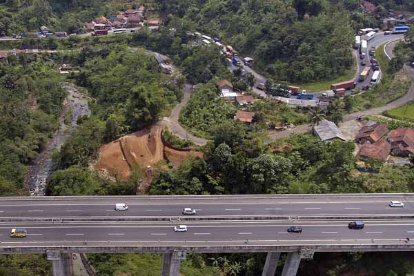 Kendaraan golongan dua yang terdiri truk dan bus melintasi jalan arteri di dekat Jembatan Cisomang jalan Tol Pubaleunyi KM 100.