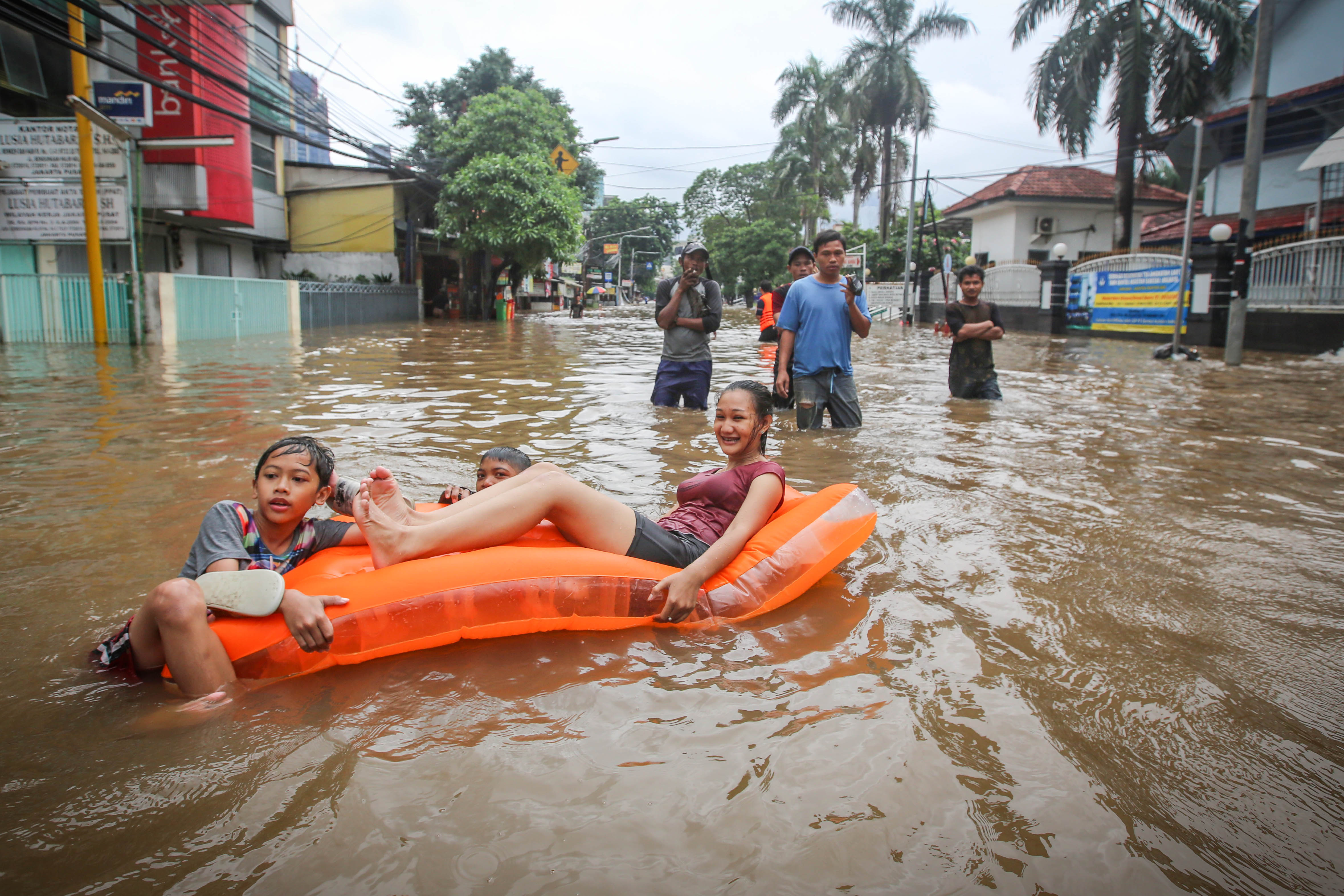 Anak-anak bermain air banjir yang menggenangi kawasan Benhil, Jakarta, Selasa (25/2/2020).