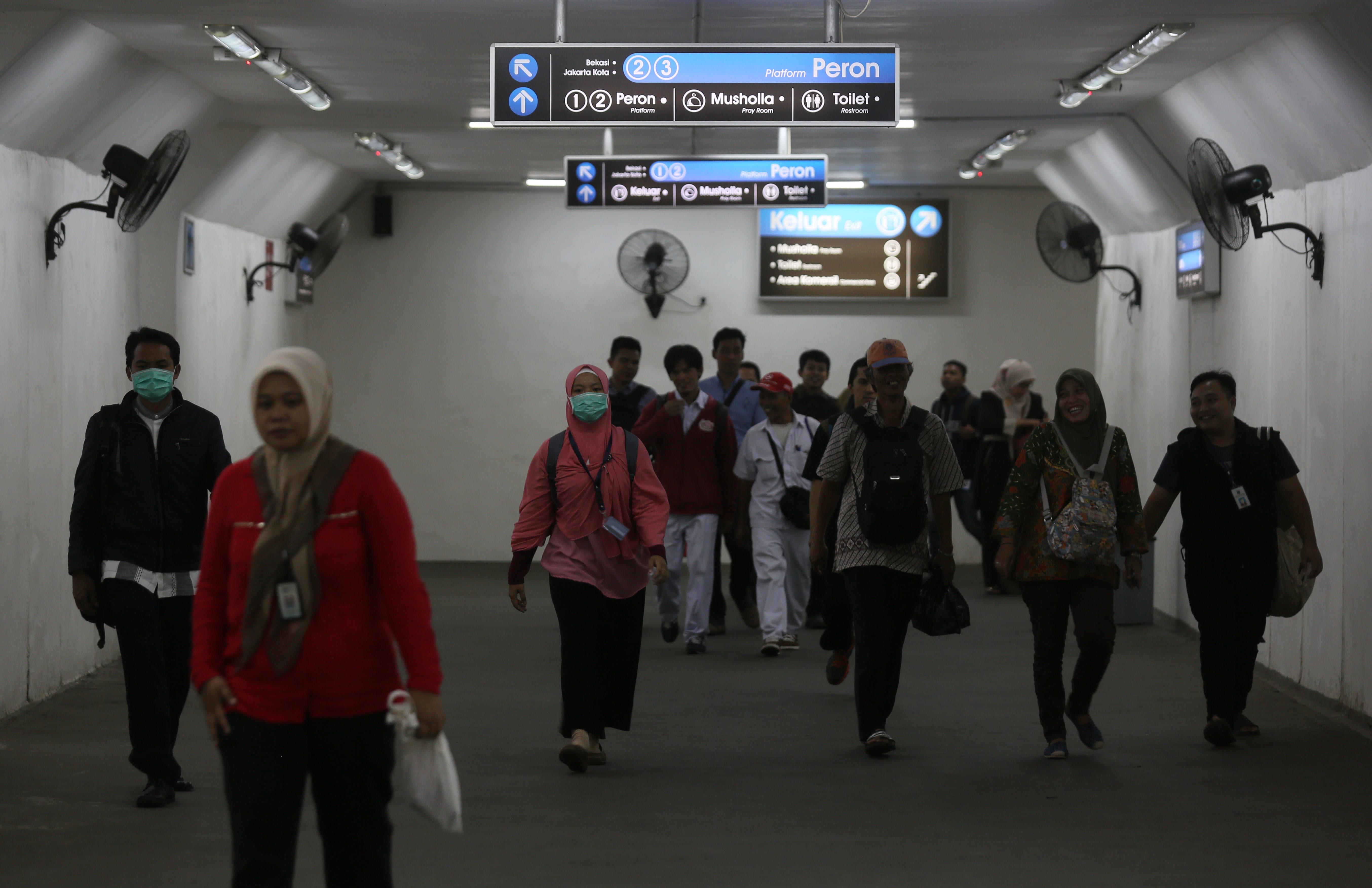 Calon penumpang kereta commuter line menyeberang peron underpass di Stasiun Manggarai, Jakarta, Kamis (26/10)