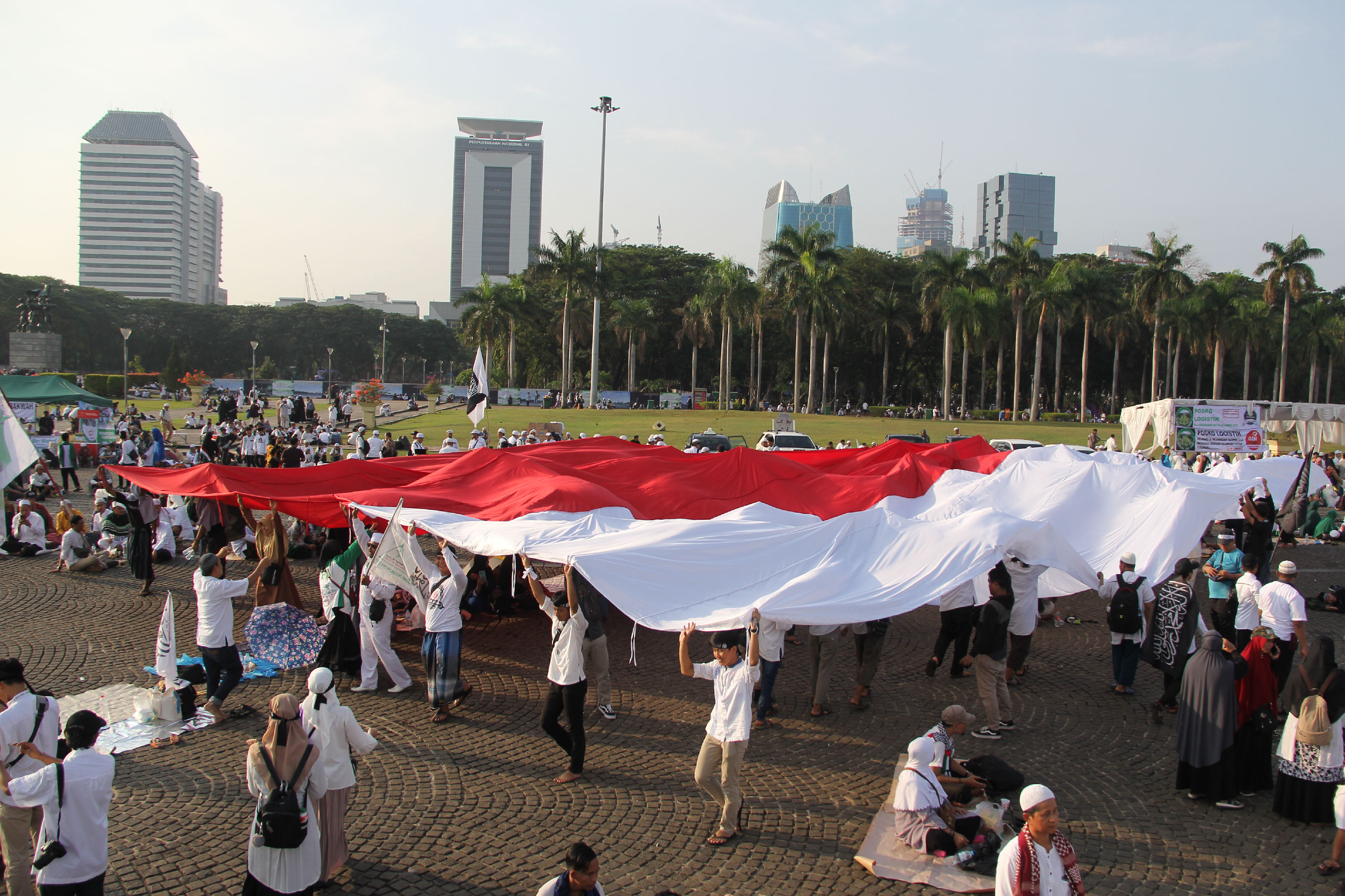 Peserta reuni 212 membentangkan bendera Merah Putih di kawasan Monas, Jakarta, Senin (2/12). 