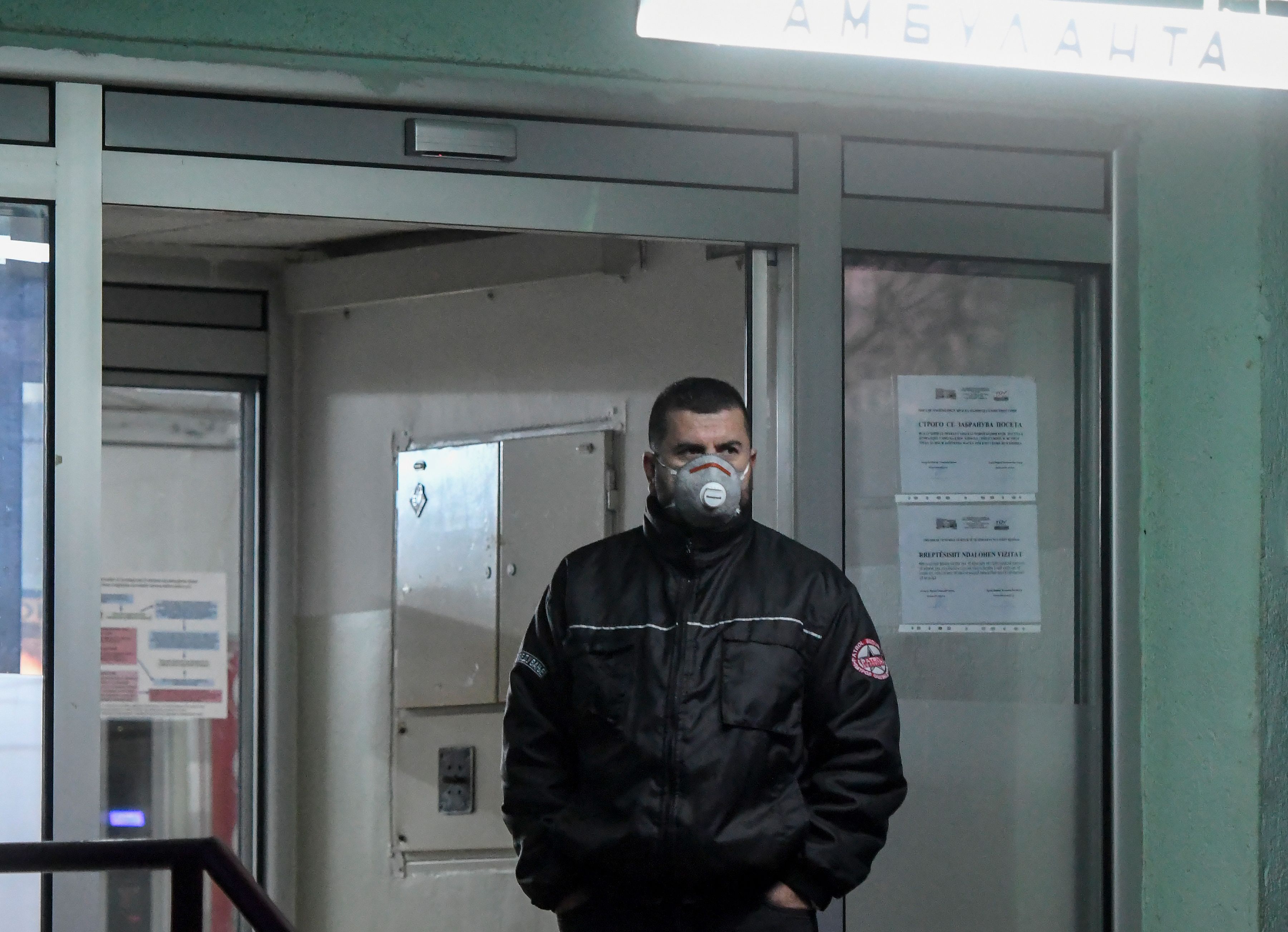 Seorang petugas keamanan mengenakan masker berjaga di University Clinic for Infectious Diseases, Skopje, Masedonia Utara.