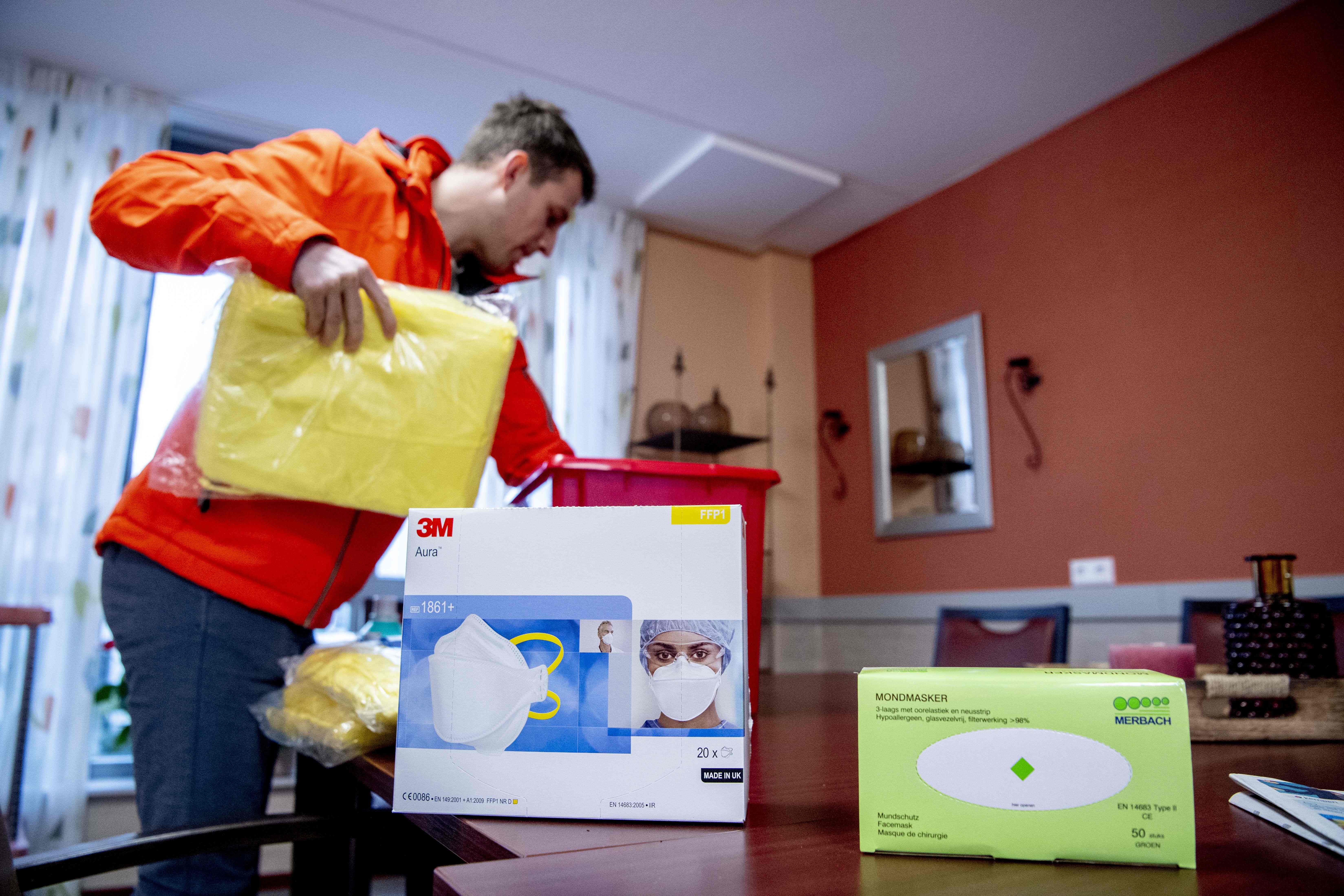 Seorang pegawai membongkar paket darurat di sebuah panti jompo untuk menghindari infeksi virus korona.