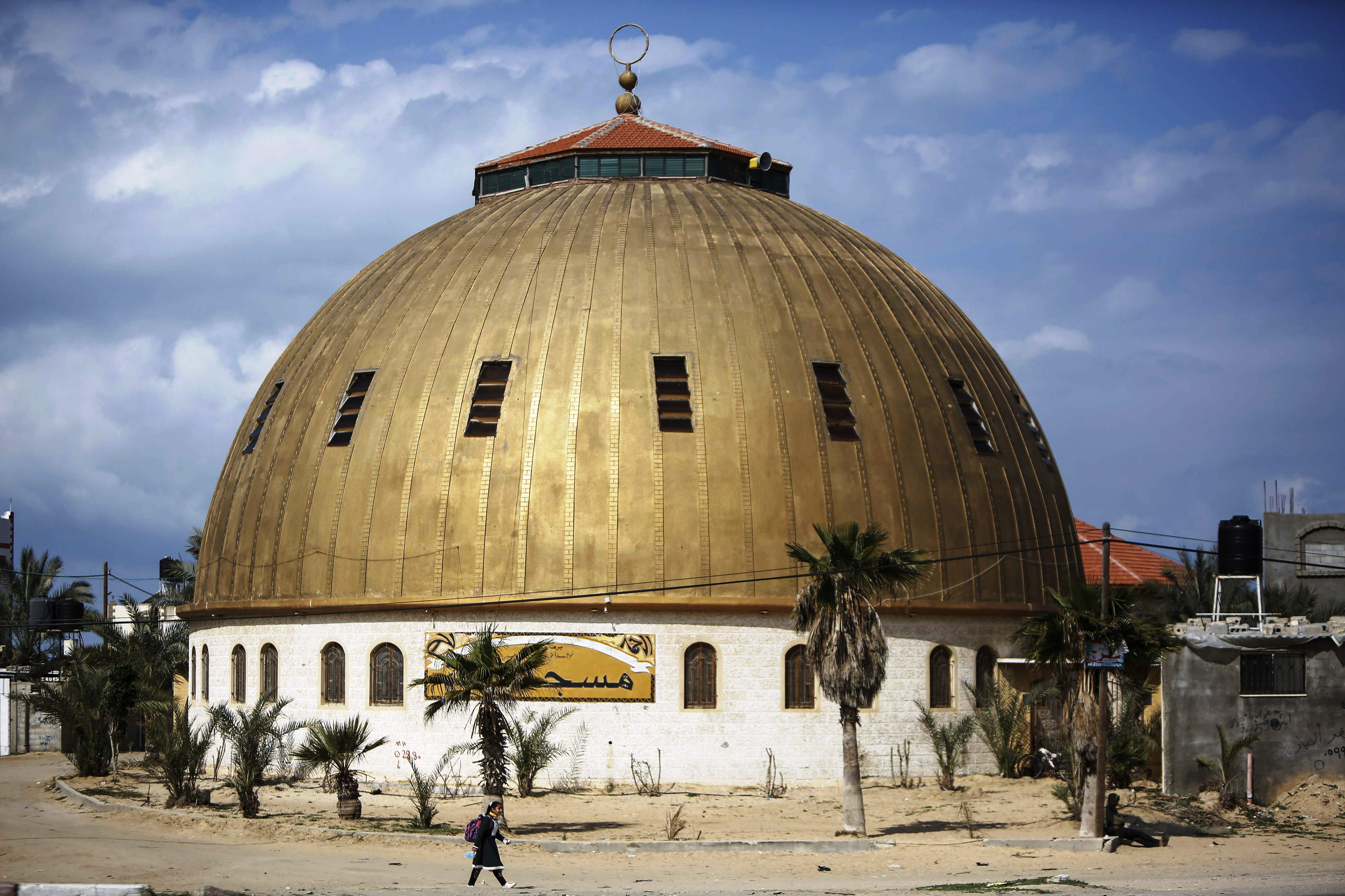 Seorang pelajar Palestina melintasi sebuah masjid di Khan Younis.