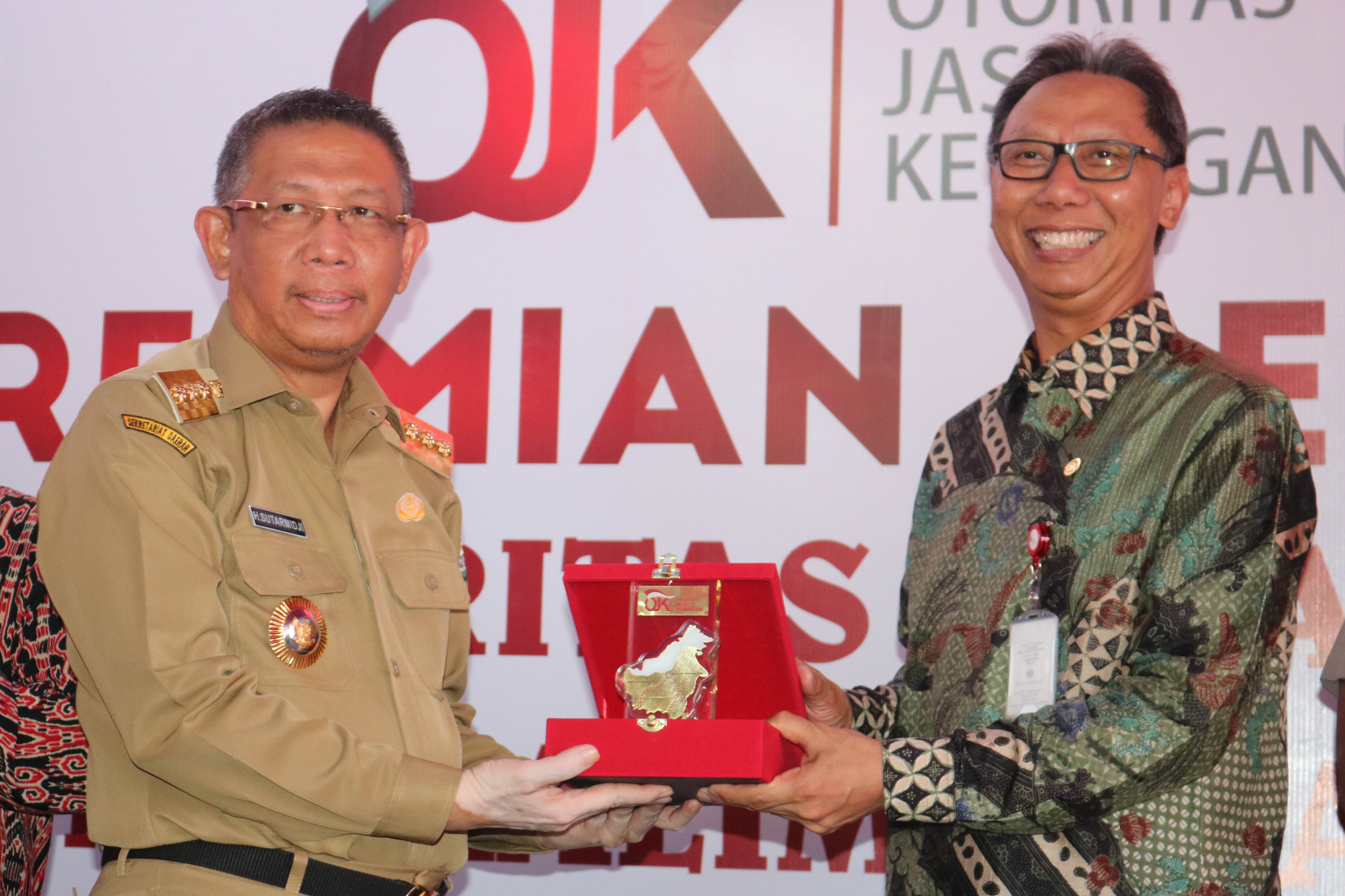 ubernur Kalbar Sutarmidji (kiri) menerima cinderamata dari Anggota Dewan Komisioner Otoritas Jasa Keuangan Tirta Segara. 