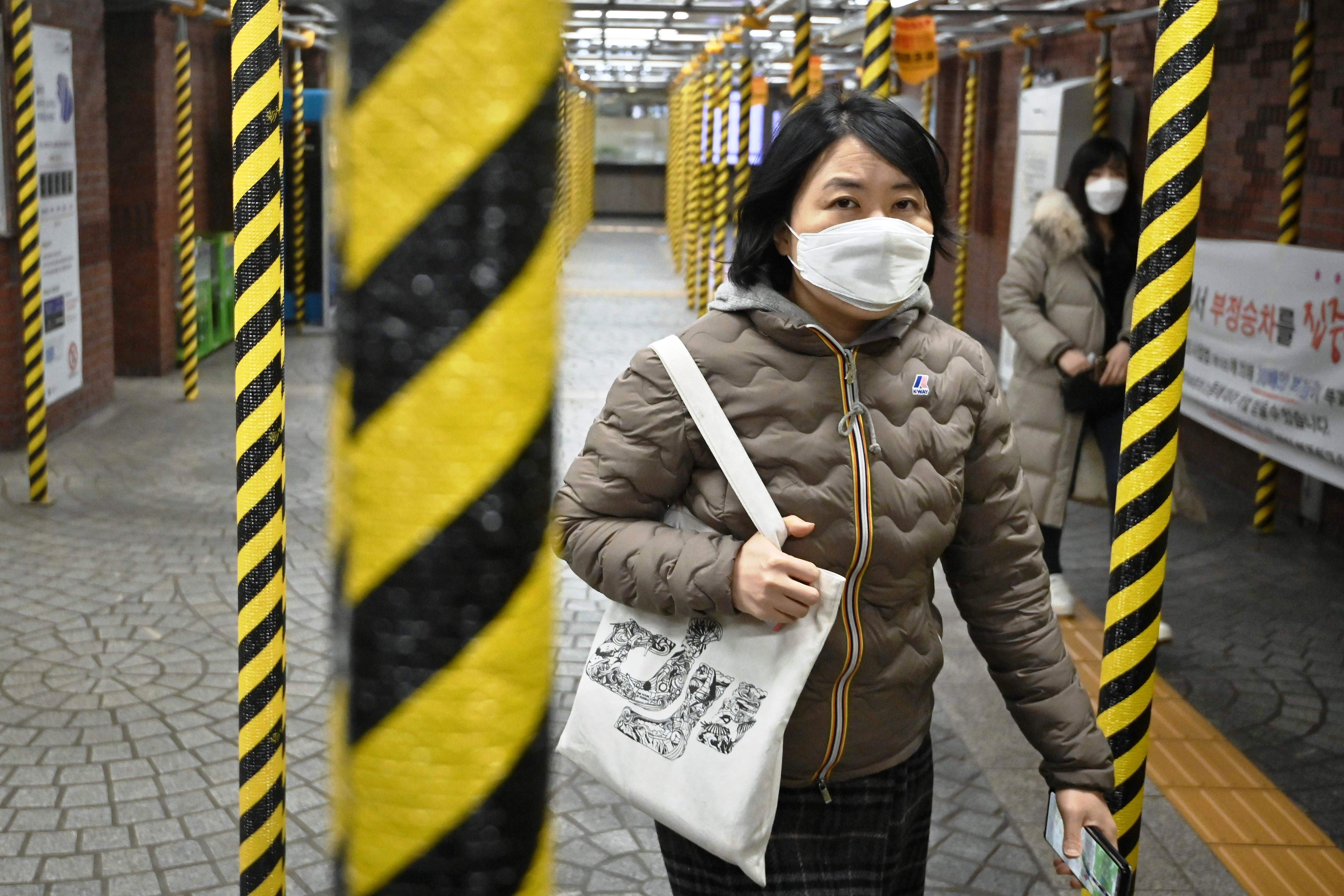 Seorang wanita bermasker di stasiun kereta di Seoul, Korsel.Korsel menjadi negara dengan warga terinfeksi Covid terbanyak di luar Tiongkok.