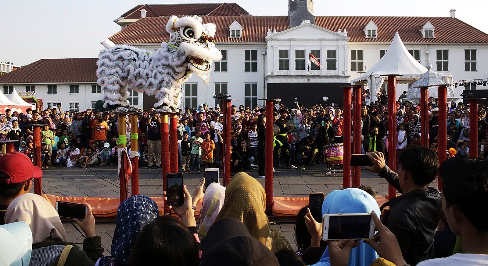 Warga menyaksikan atraksi barongsai saat pergelaran Festival Pecinan Batavia 2019 di Taman Fatahillah, Kawasan Kota Tua.