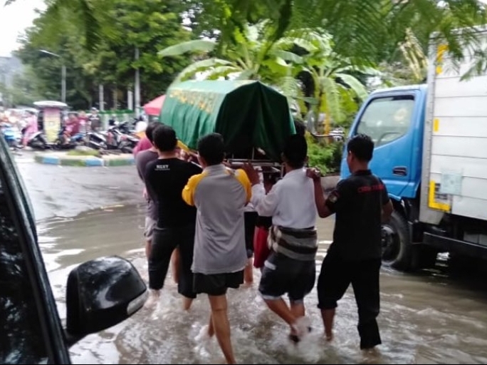 Warga menembus banjir untuk mengantar jenazah di Jakarta, Minggu (23/2)
