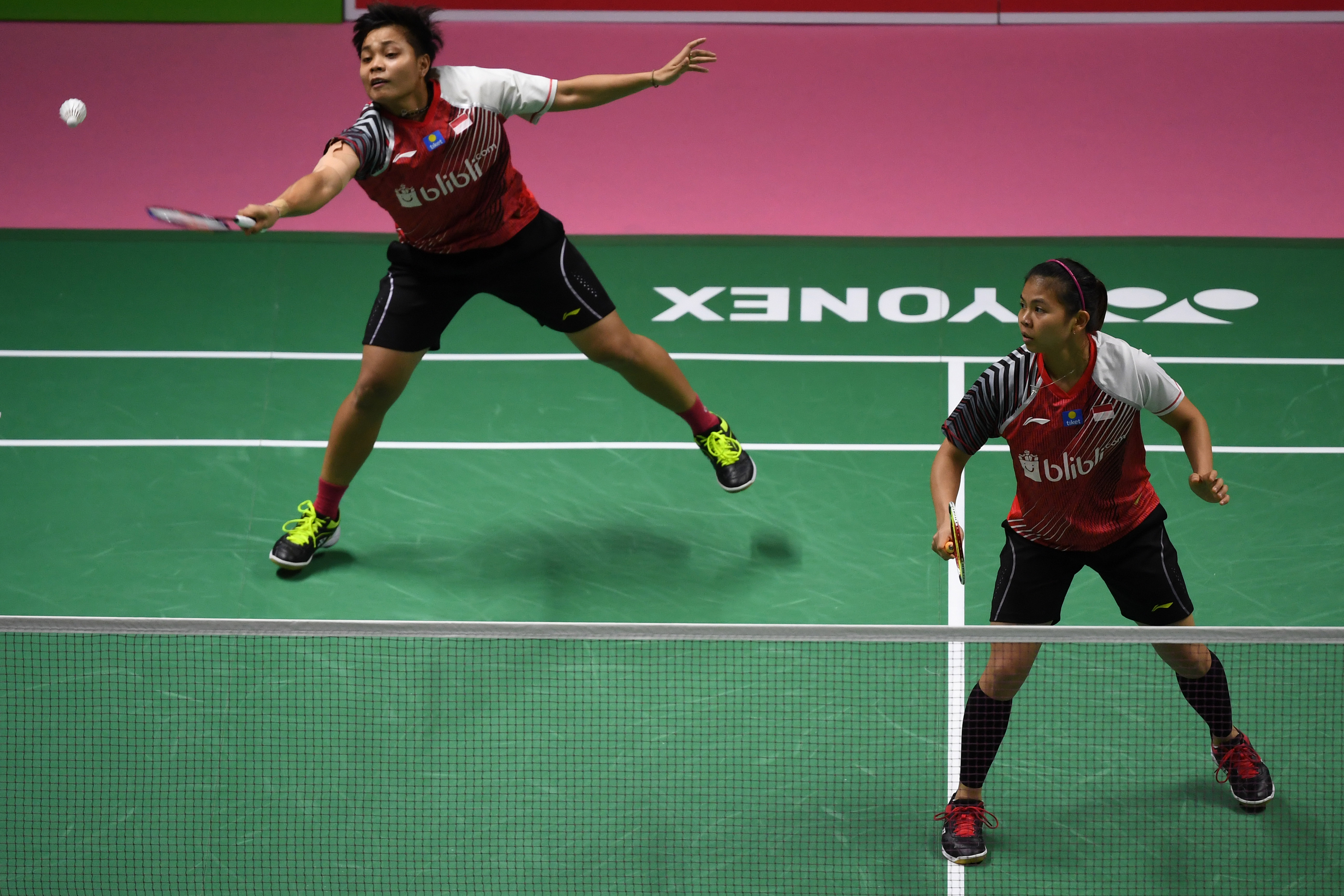 Pebulu tangkis ganda putri Indonesia Apriyani Rahayu (kiri) mengembalikan kok disaksikan rekannya dan Greysia Polii (kanan).