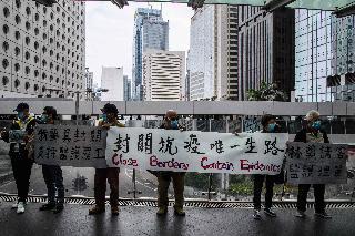 Para demonstran di Hong Kong, Senin (3/3) membentangkan spanduk yang meminta pemerintah Hong Kong menutup perbatasan dengan Tiongkok.  