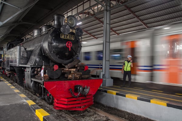 Petugas berdiri di samping lokomotif uap saat tiba di Stasiun Purwosari, Solo, Jawa Tengah, Kamis (6/2/2020).