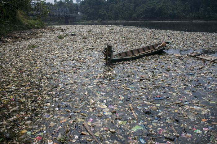 Warga menggunakan perahu untuk memilah sampah plastik di aliran Sungai Citarum, Batujajar, Kabupaten Bandung Barat, Jawa Barat.