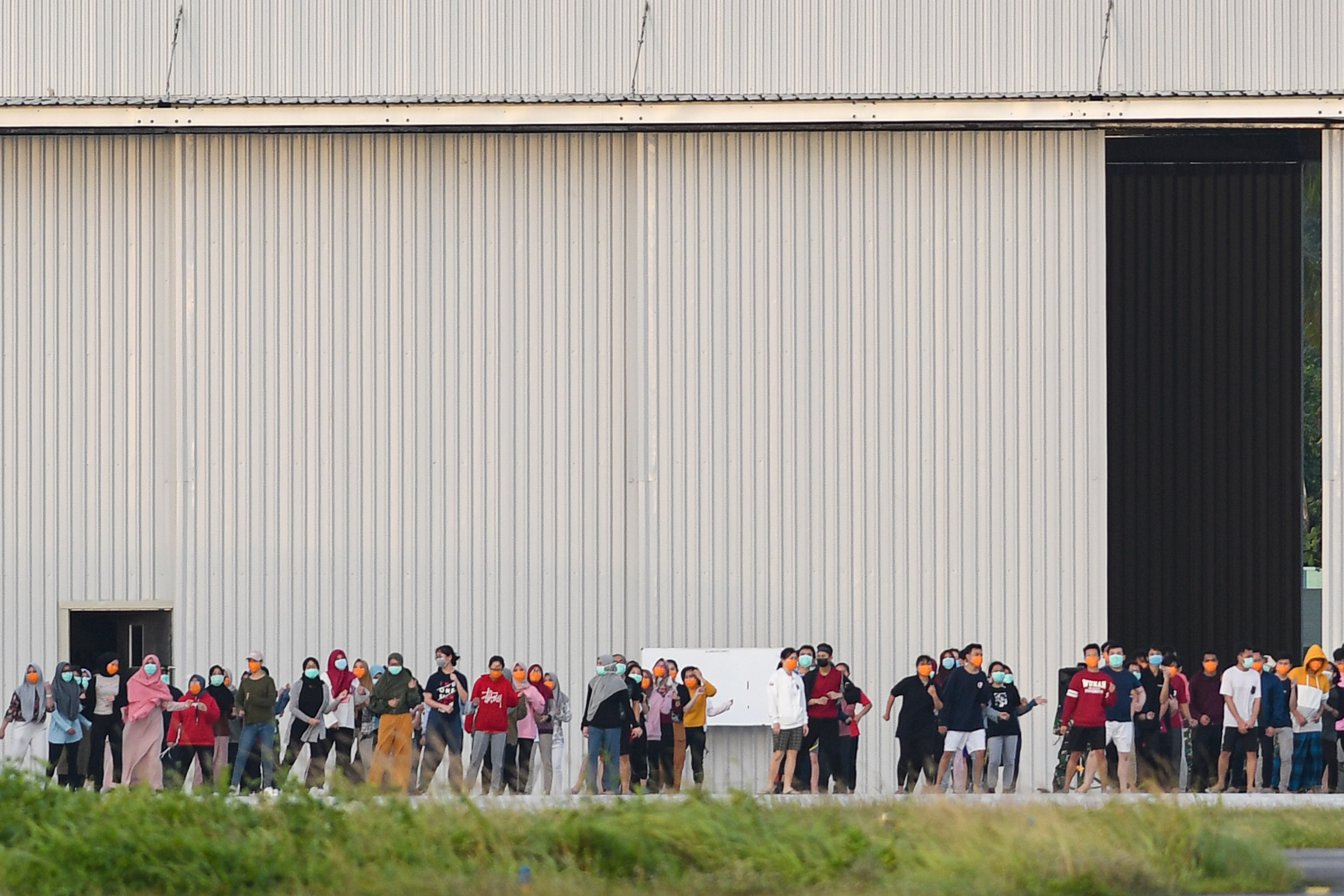 WNI  yang dikarantina  senam bersama prajurit TNI di Hanggar Pangkalan Udara TNI AU Raden Sadjad, Ranai, Natuna, Kepri, Kamis (6/2/2020).