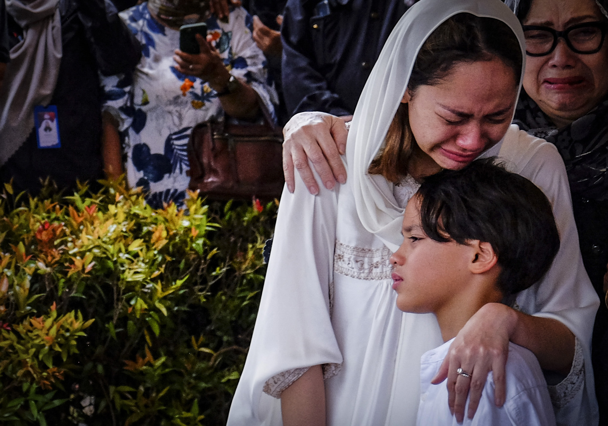 Bunga Citra Lestari memeluk anaknya Noah Sinclair saat pemakaman Ashraf Sinclair.
