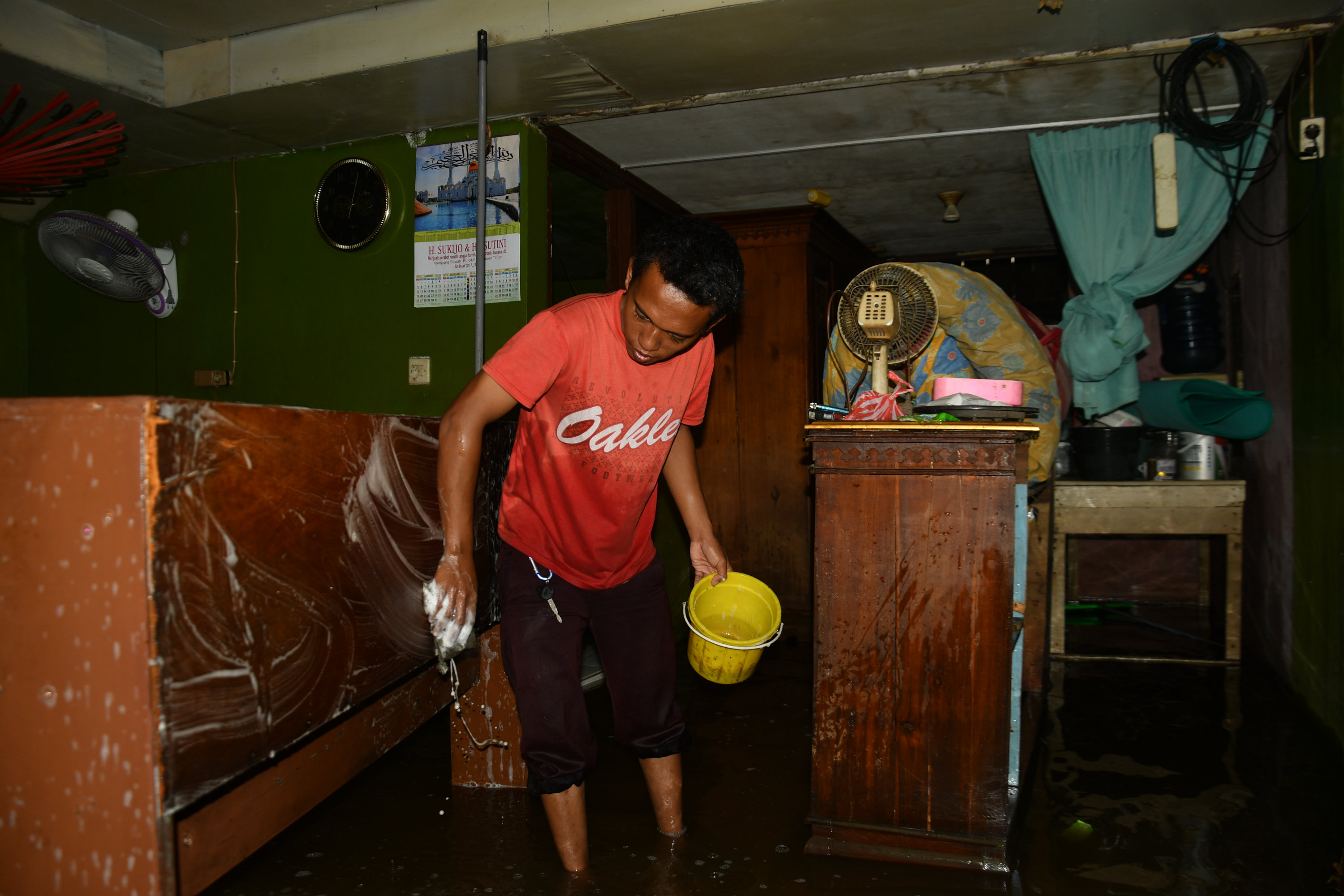 Warga mulai membersihkan rumahnya yang terendam banjir di kawasan Rorotan, Jakarta Utara, Rabu (26/2).