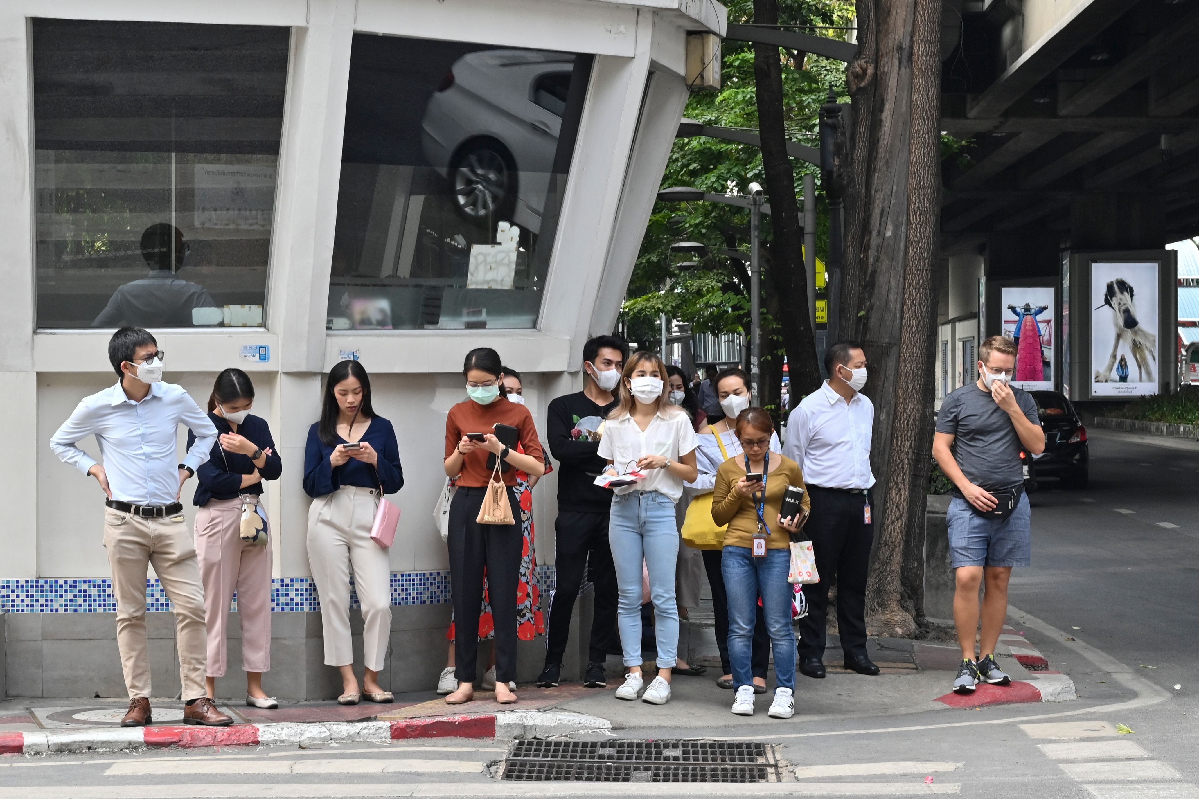 Sejumlah warga mengenakan masker saat menunggu menyeberang jalan di Kota Bangkok.